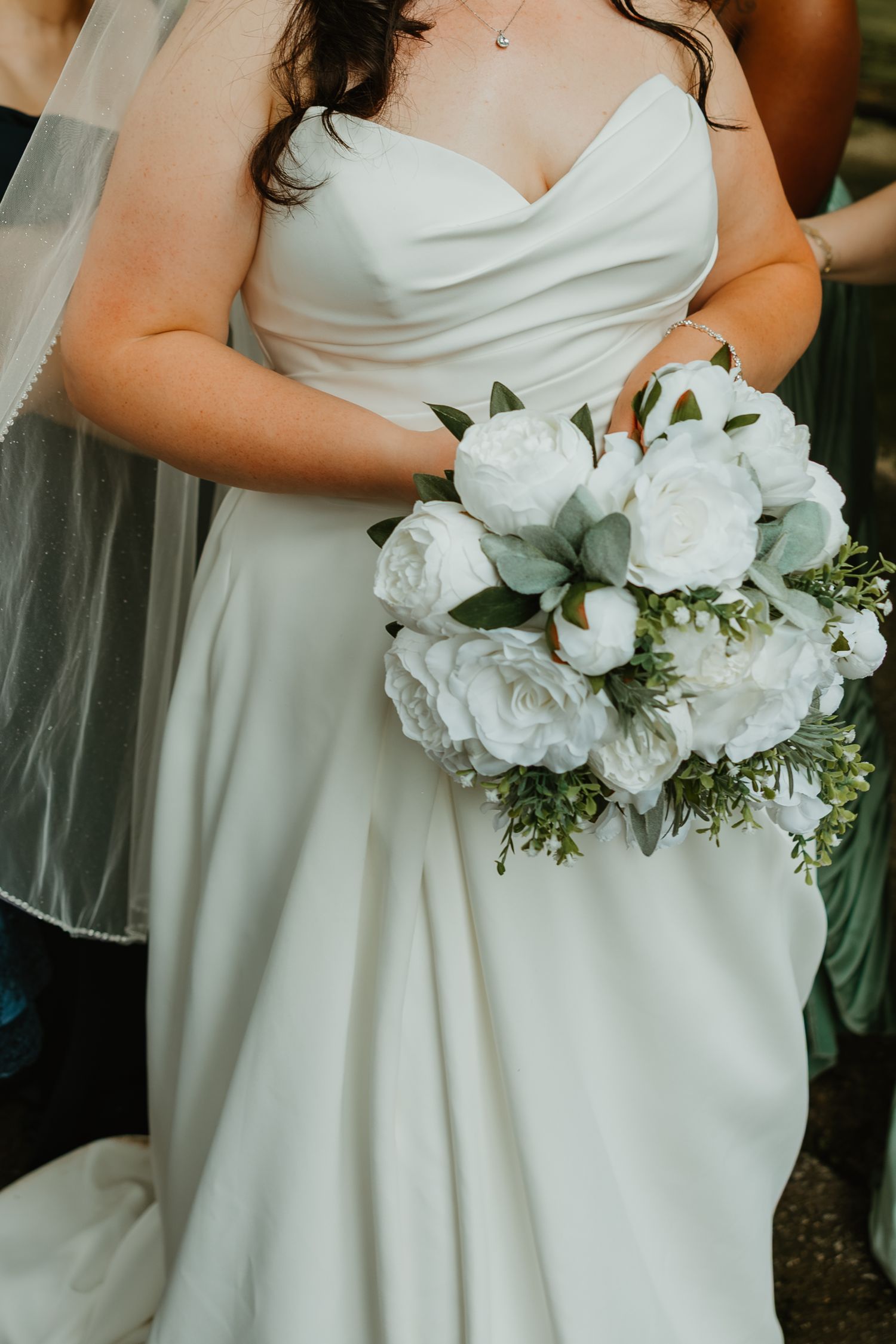 Bride in strapless white wedding gown holds lush white peony and eucalyptus bridal bouquet. Northwest Indiana wedding venues.