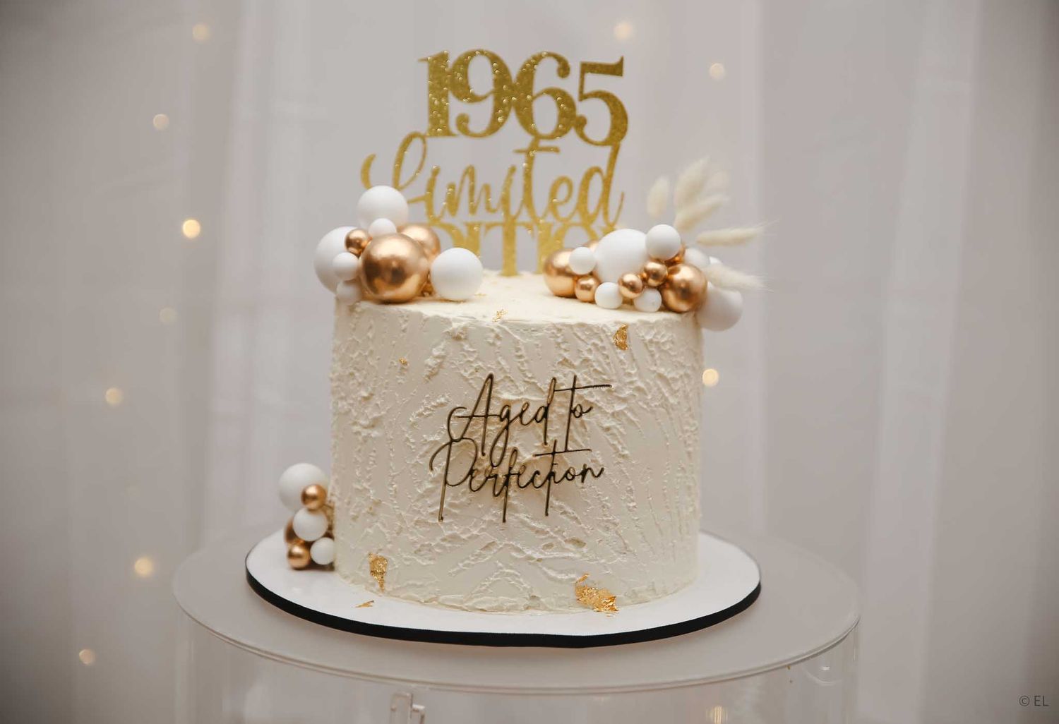 Elegant 1965 Limited Edition birthday cake decorated with gold topper and pearl accents.