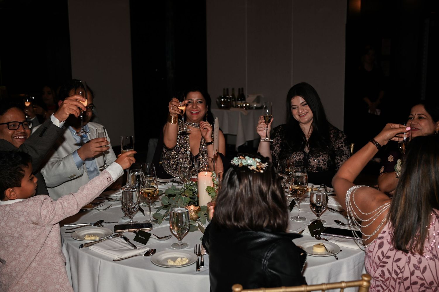 Wedding guests raise glasses in a toast at a elegantly set reception dinner table  at The Pendry Hotel in Chicago Illinois.