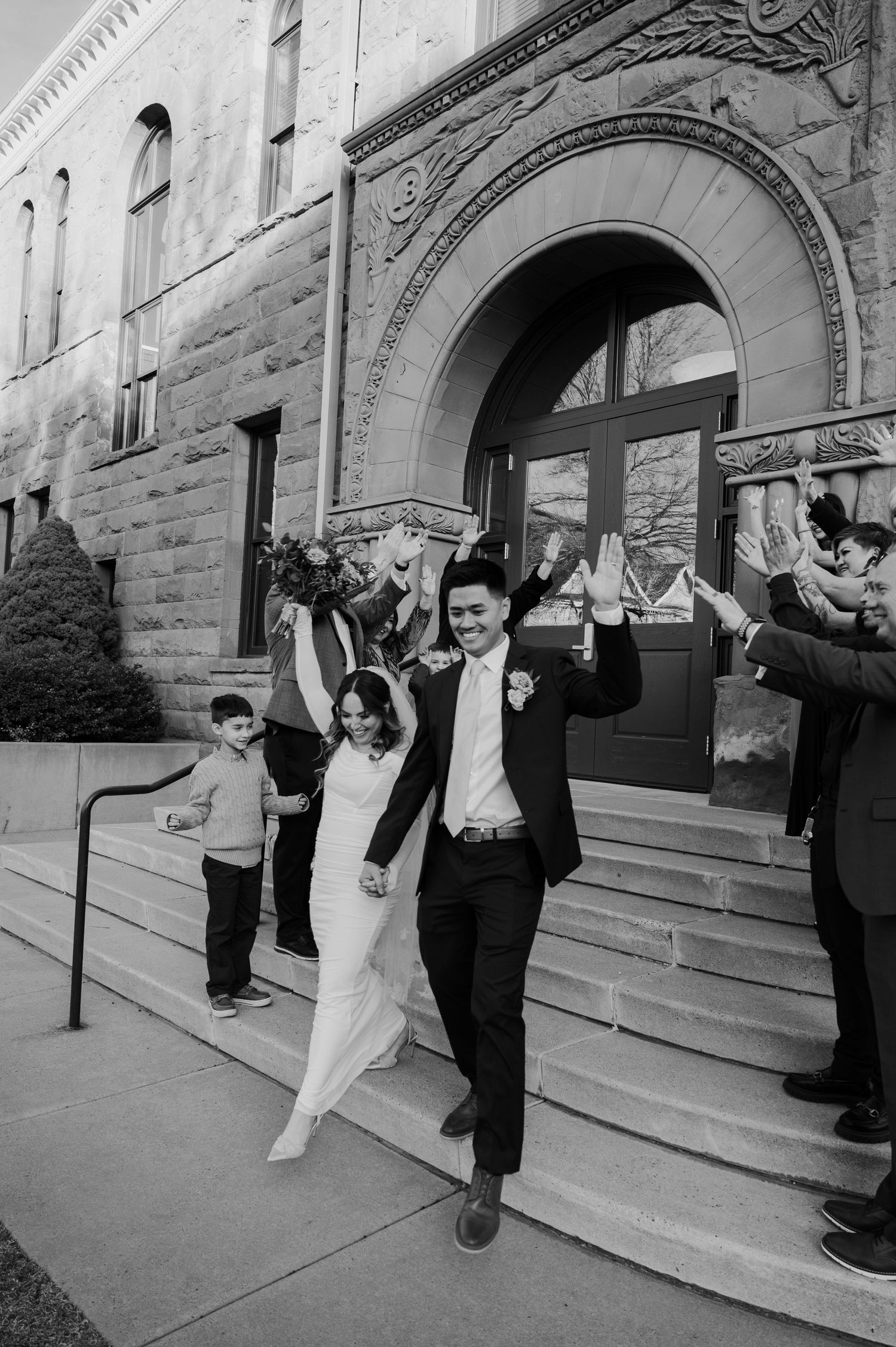 Newlyweds exit historic stone courthouse steps as guests celebrate their marriage in Flagstaff at the Flagstaff courthouse in Arizona.