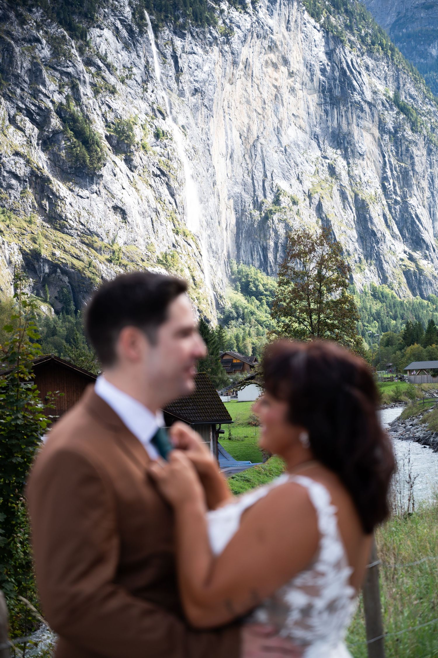 Bride and groom sharing a tender moment with a majestic Swiss waterfall cliff backdrop in Lauterbrunnen.