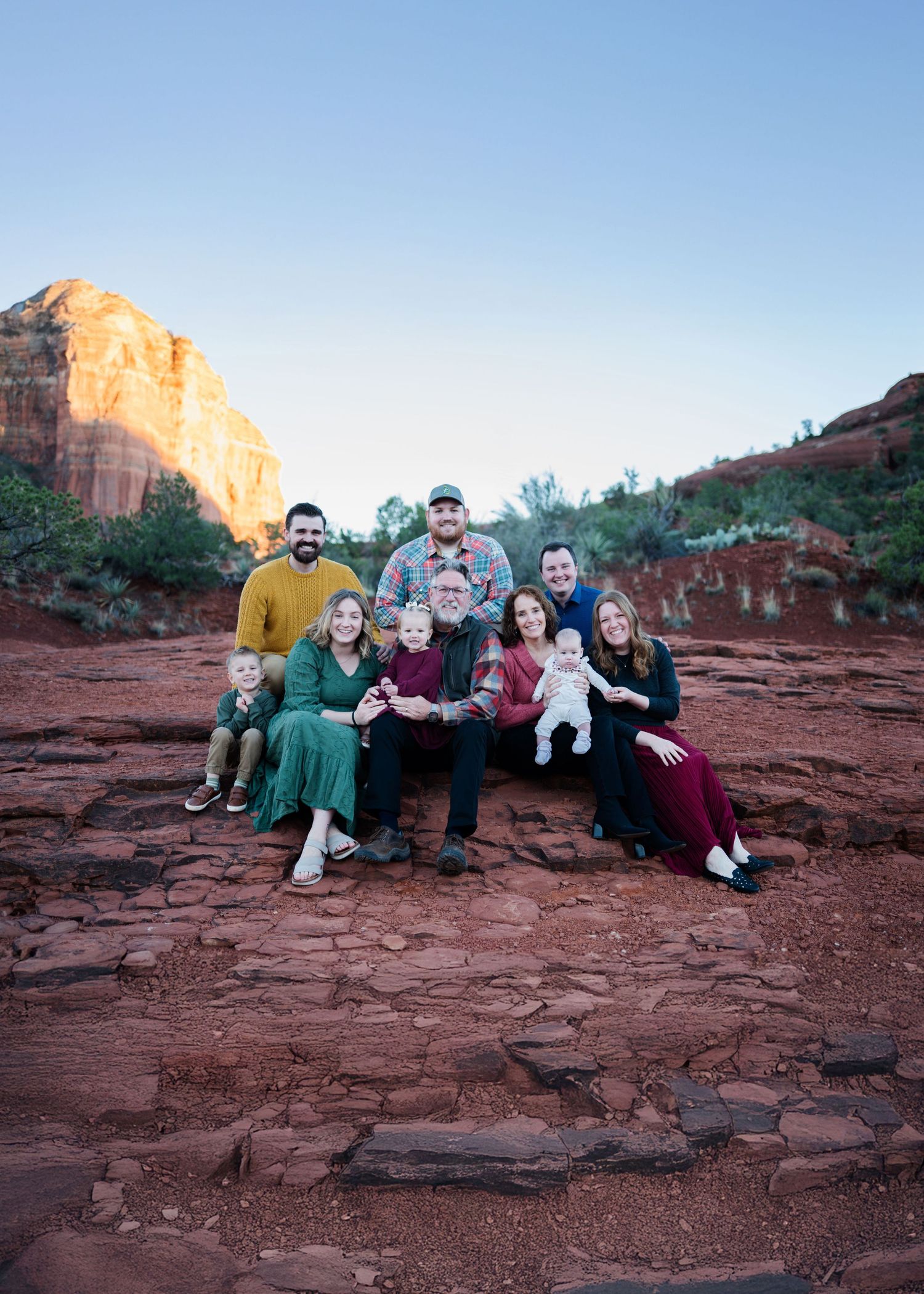 Multi-generational family portrait on red rock formations at sunset in Sedona, Arizona.