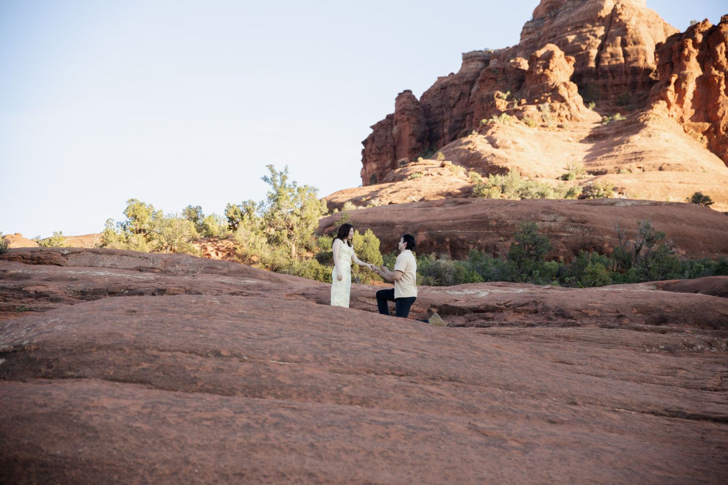 Couple exchanging vows on red rock formations in a stunning desert landscape ceremony. Proposal in sedona