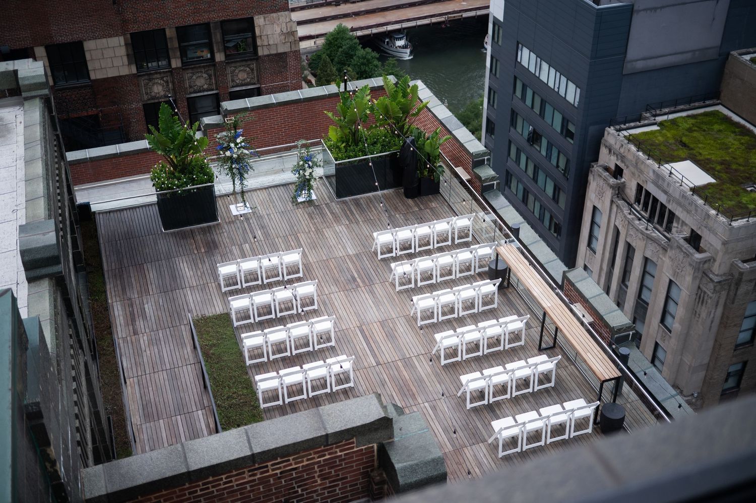 Aerial view of rooftop wedding ceremony setup with white chairs on urban building at The Pendry Hotel in Chicago Illinois.