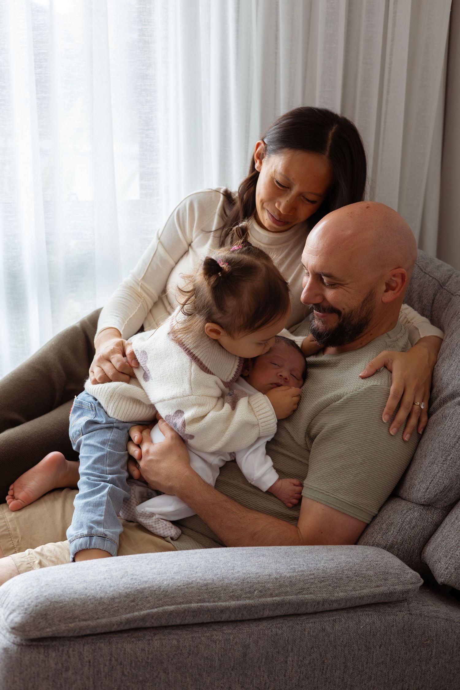 Family welcoming their newborn during a relaxed lifestyle photography session.