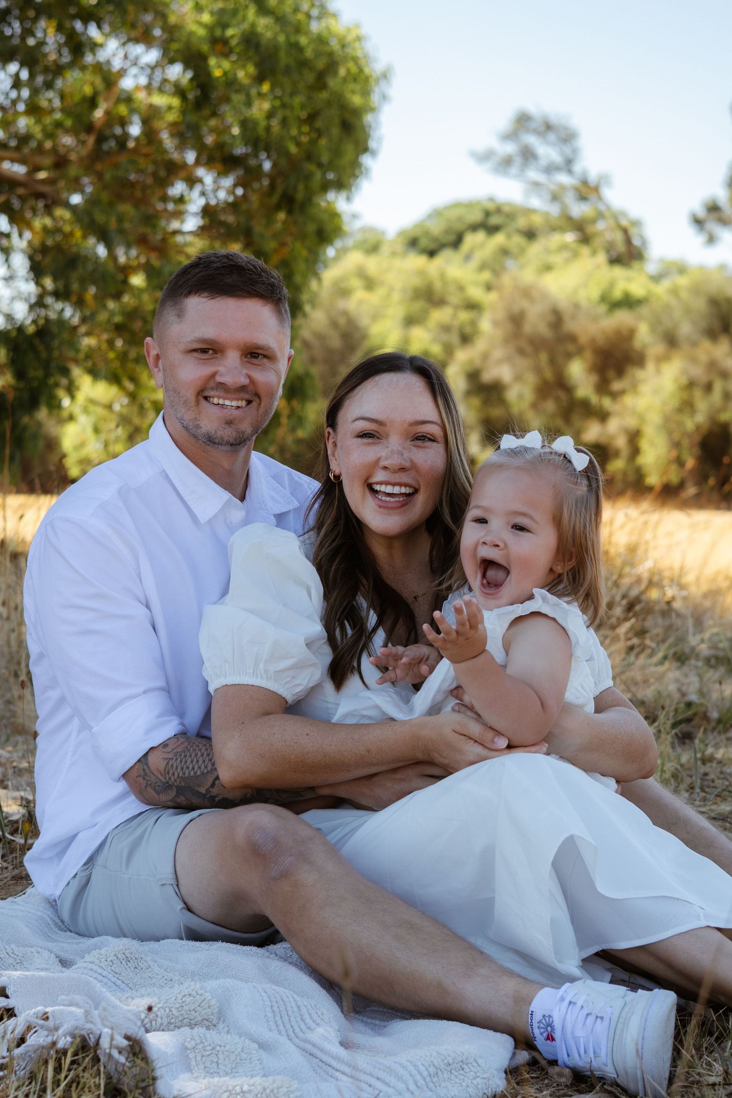 Family of 3 in perth field having a fun, warm and candid photoshoot