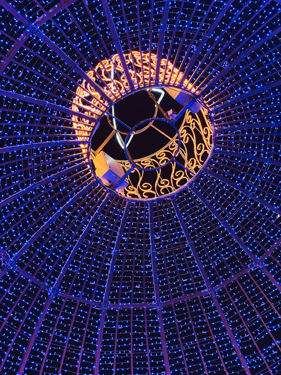 Blue LED dome ceiling with glowing orange center circle and geometric mirror art installation viewed from below.