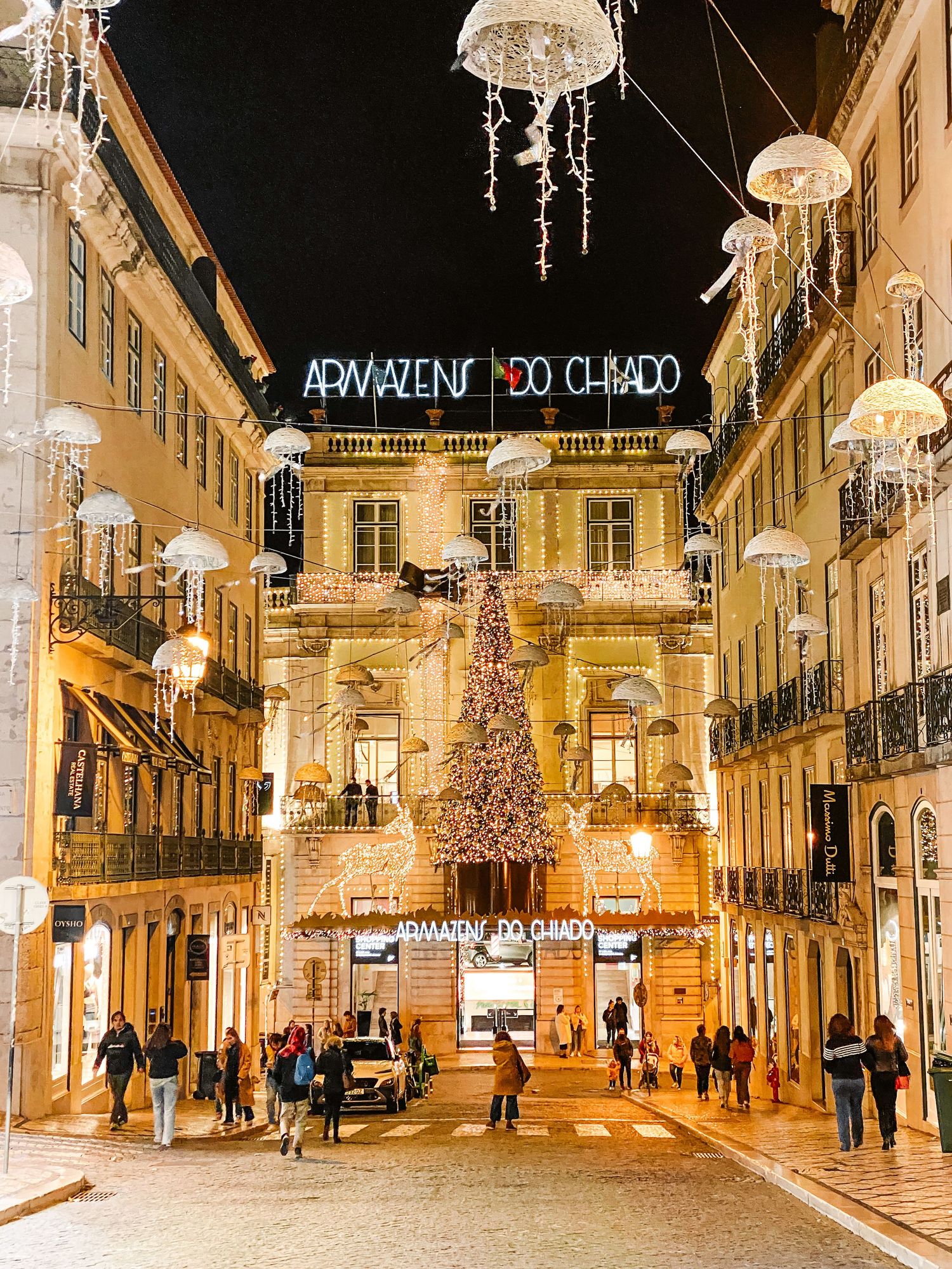 Lisbon Chiado district at night with Christmas tree and jellyfish lights decorating the festive shopping street.