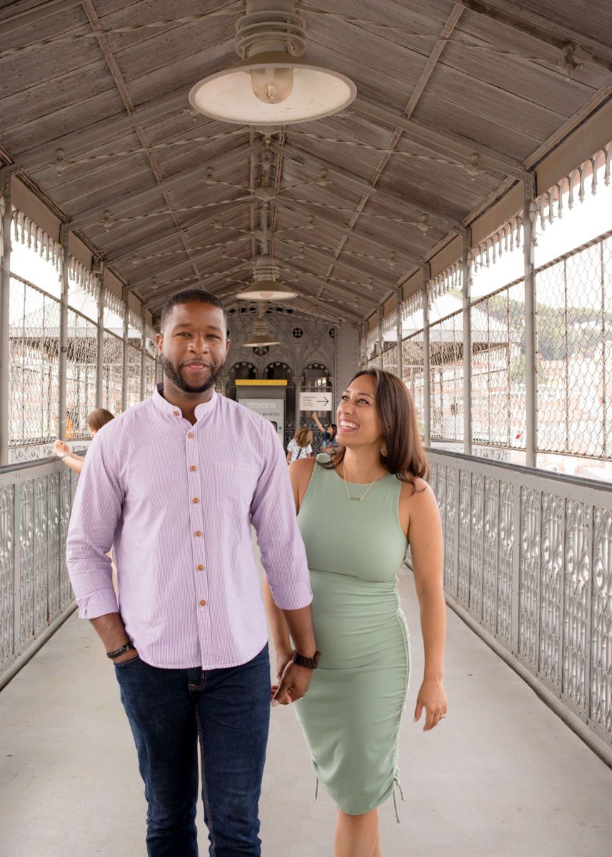 Couple walking hand in hand through a vintage covered iron bridge corridor together.