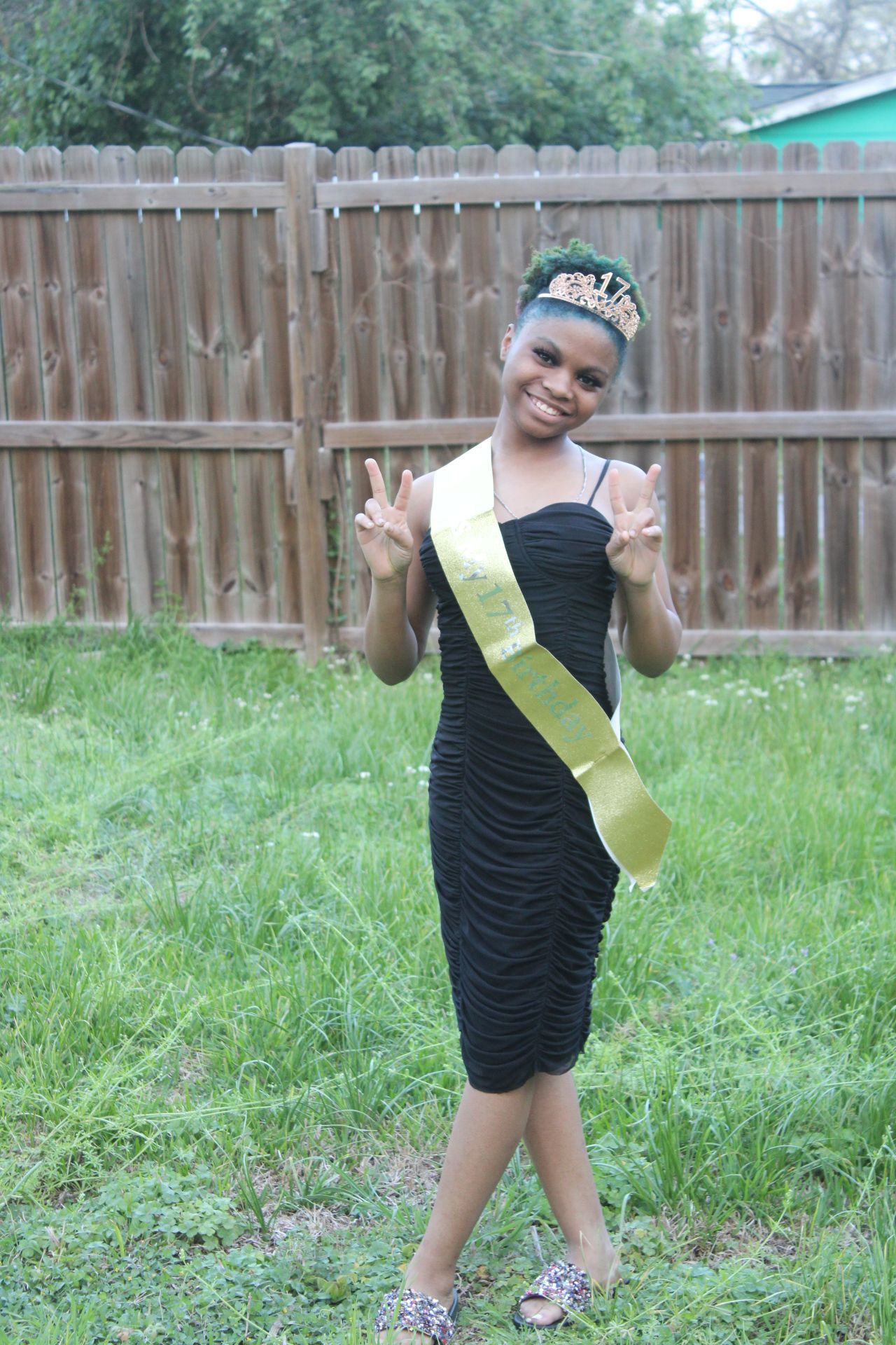 Outdoor portrait of a woman in a black dress posing in a backyard, photographed by ISHANIKA_PHOTOS_.