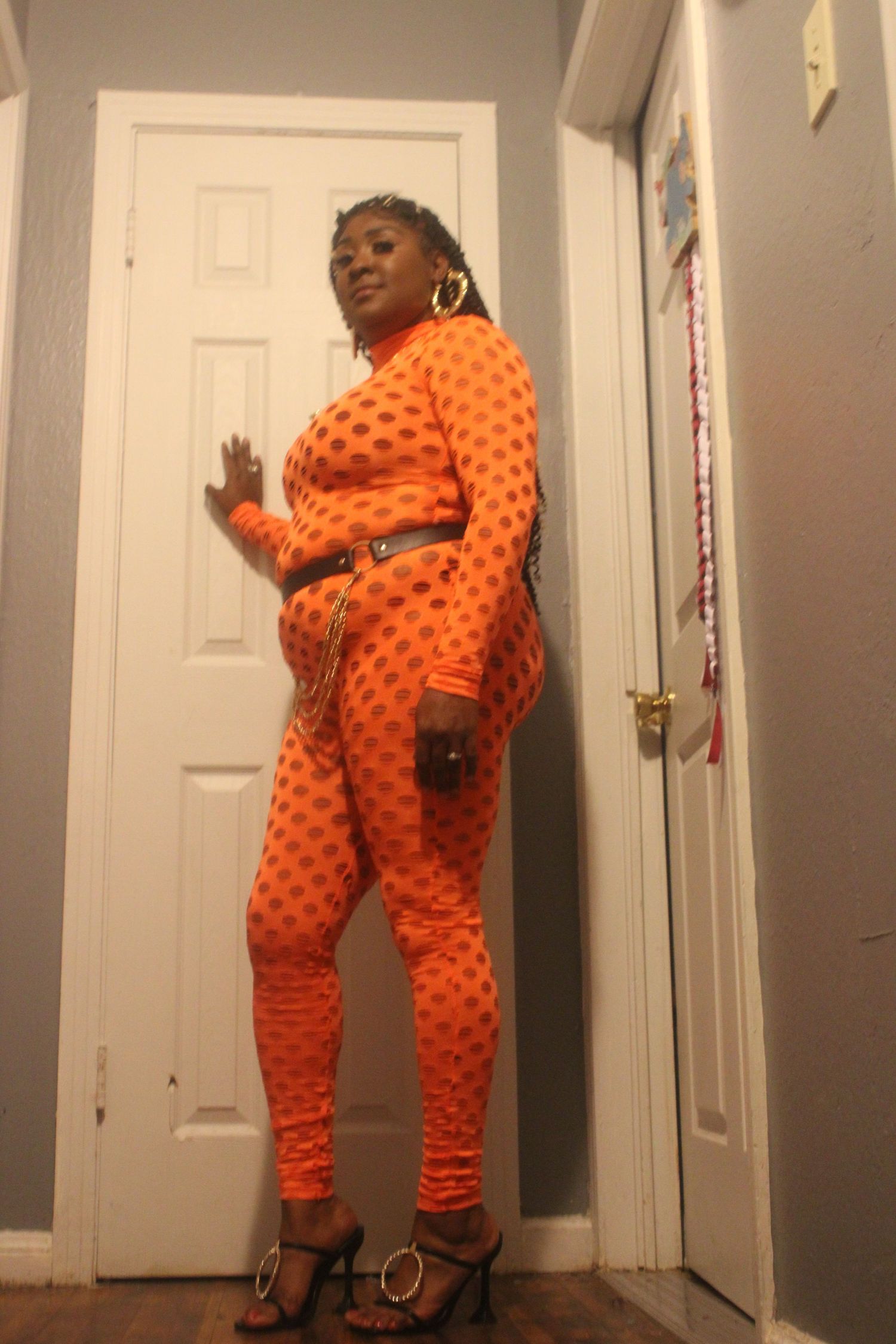 Portrait of a woman wearing an orange outfit posing indoors, photographed by ISHANIKA_PHOTOS_.