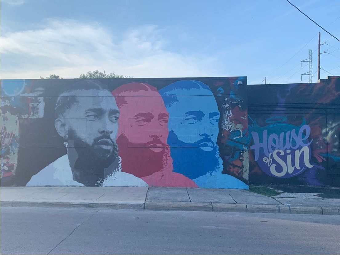 Colorful street mural featuring portraits of men in red and blue tones with House of Sin text on building exterior.