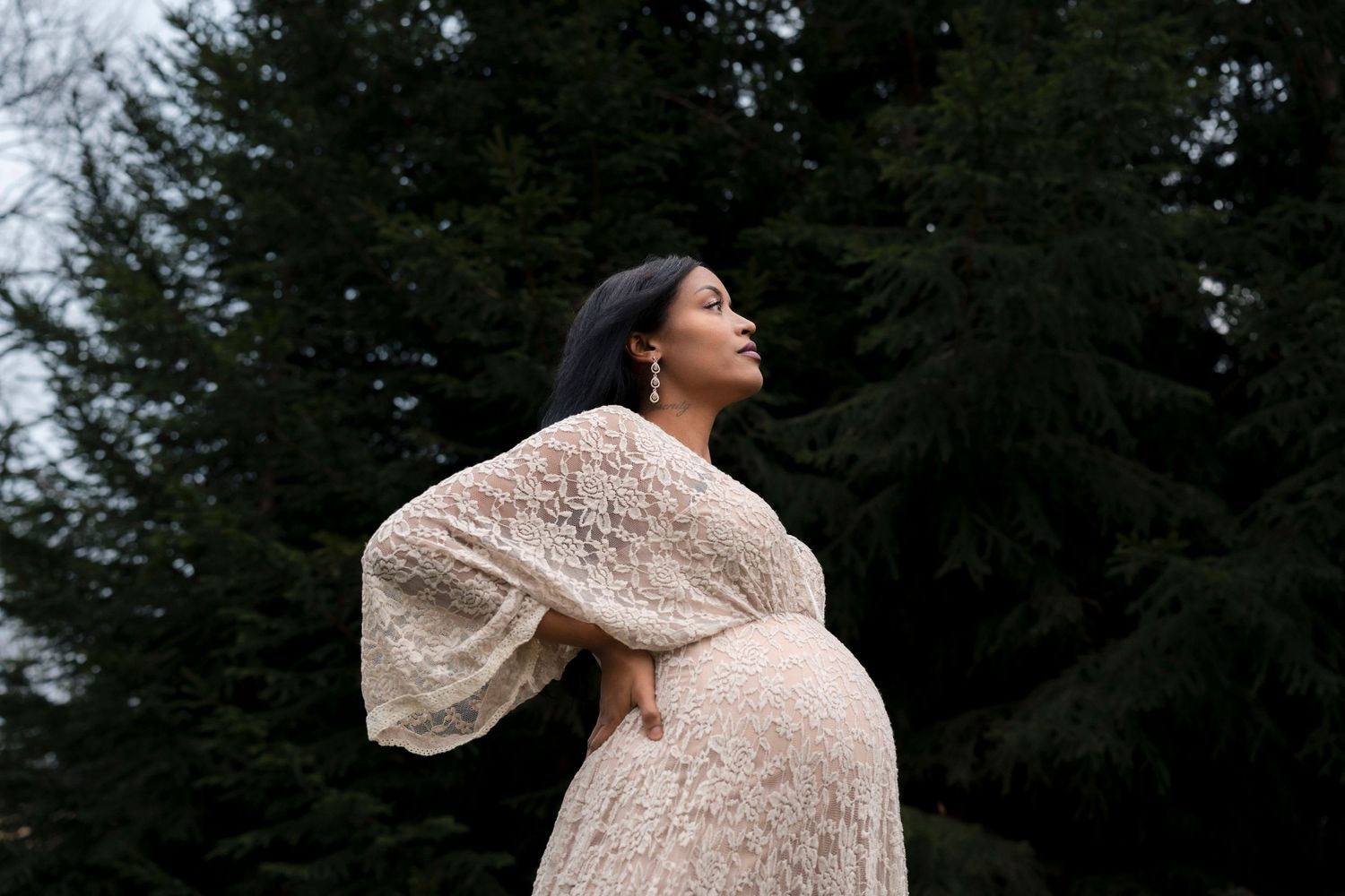 A person wearing a beige knit sweater poses against a dark forest background in multiple artistic shots.