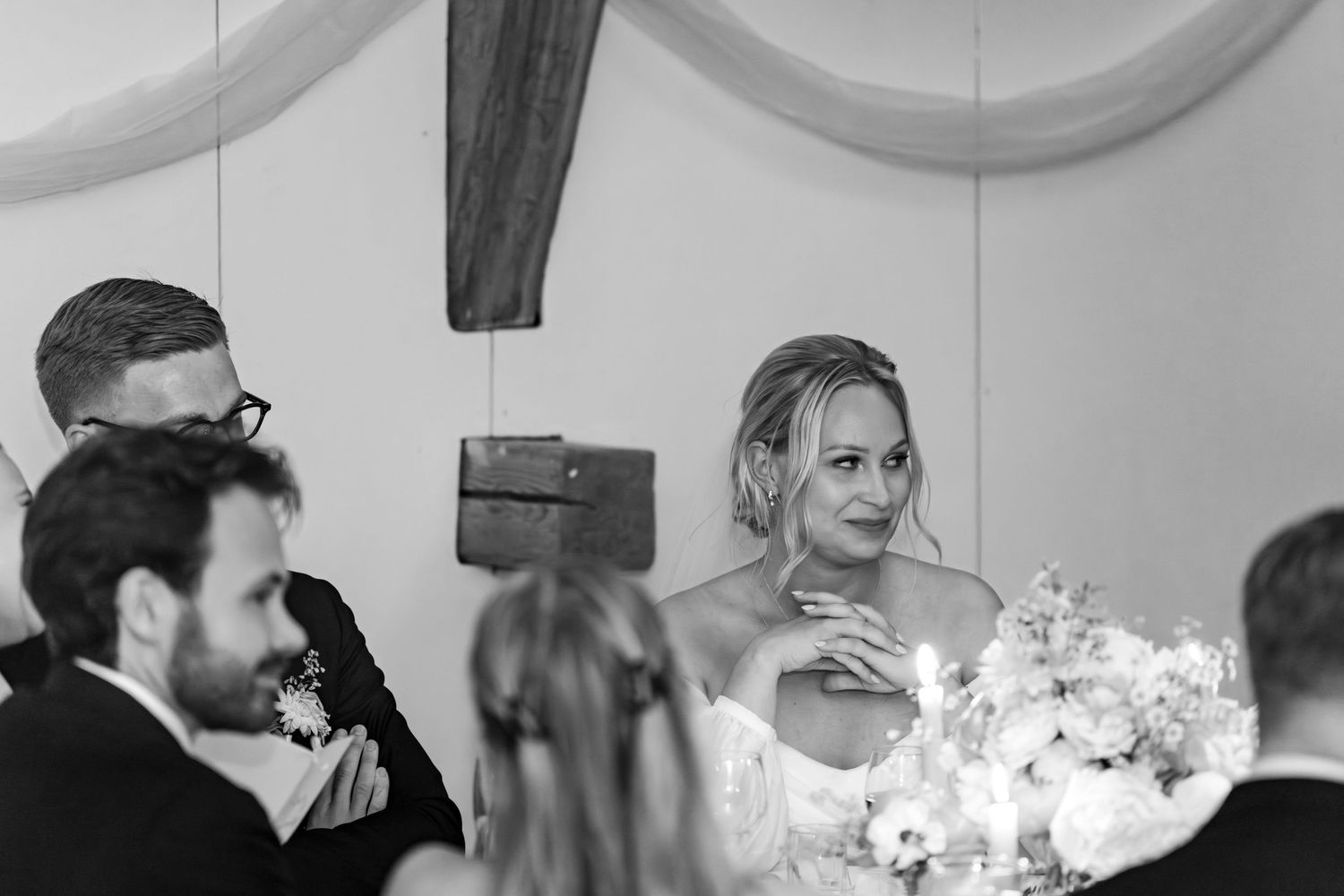 A black and white photo collage shows four candid moments during a wedding celebration.