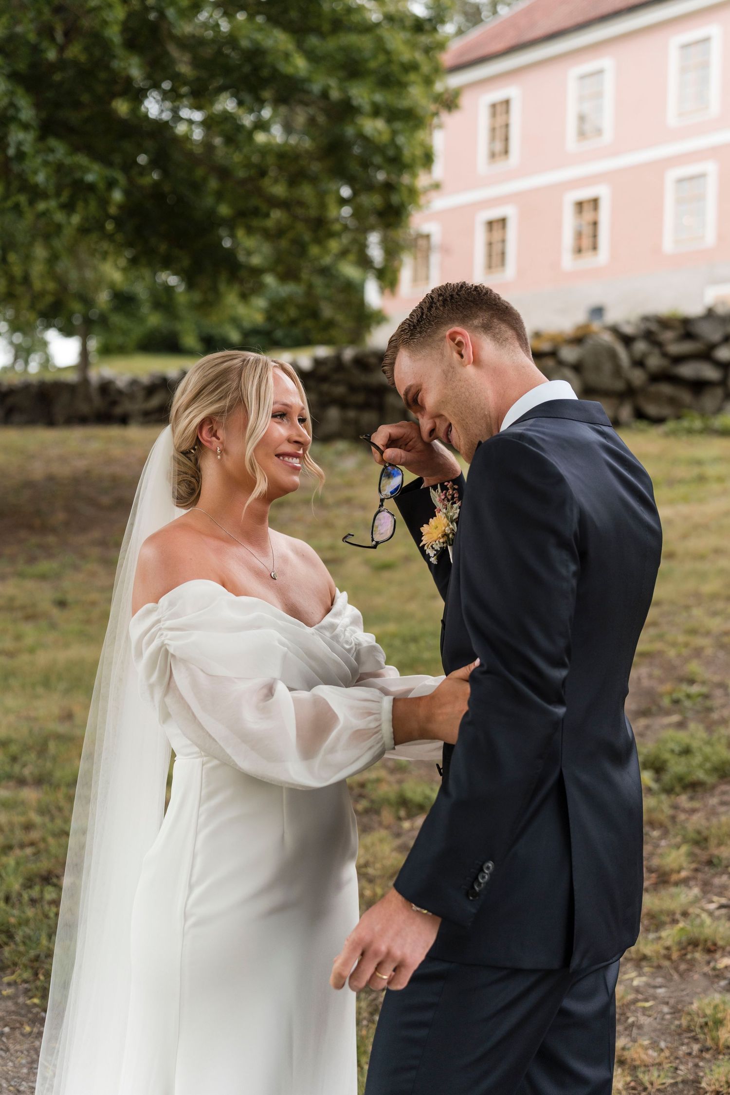 A bride and groom share a candid moment outdoors near a pink building, shown in a series of progressive shots.