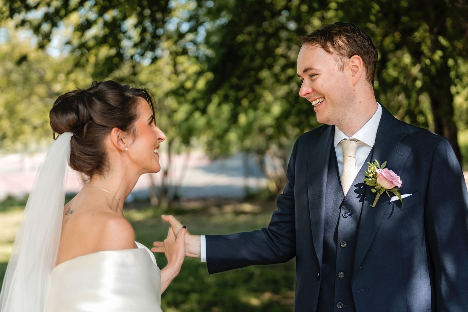Cheerful newlywed couple shares intimate moments in a romantic garden setting on their wedding day.