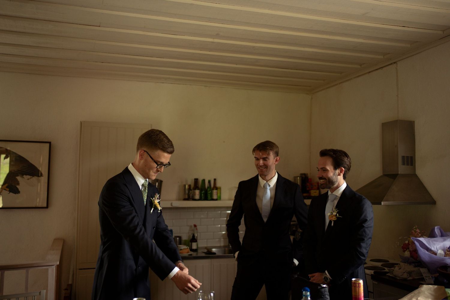 Group of people in formal attire gather in a dimly lit room with wood paneled walls and ceiling.