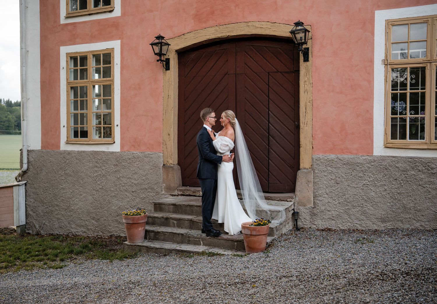 A series of four wedding photos showing couples in romantic poses against a pink stone building exterior.