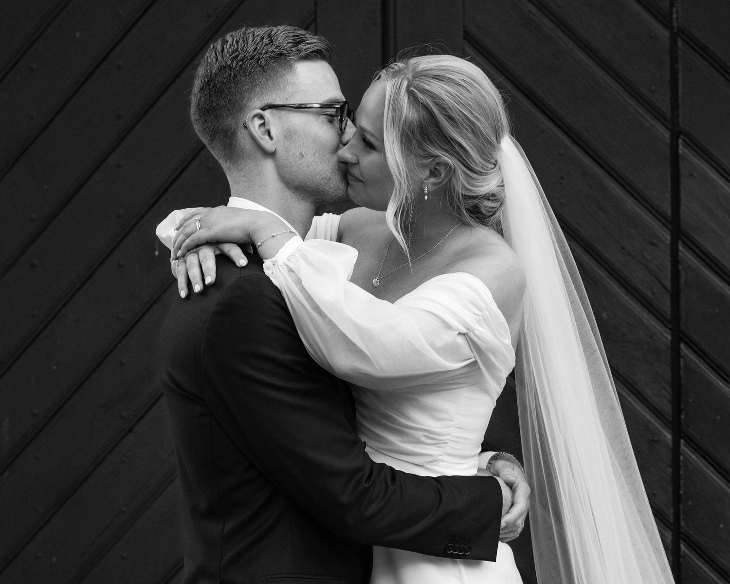 A romantic black and white wedding photo series showing a couple kissing in five sequential frames.