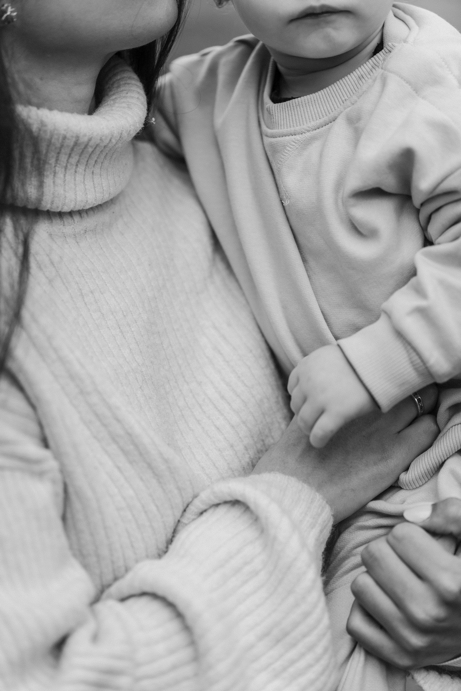Close-up black and white photo showing a person wearing a cozy white knit sweater.