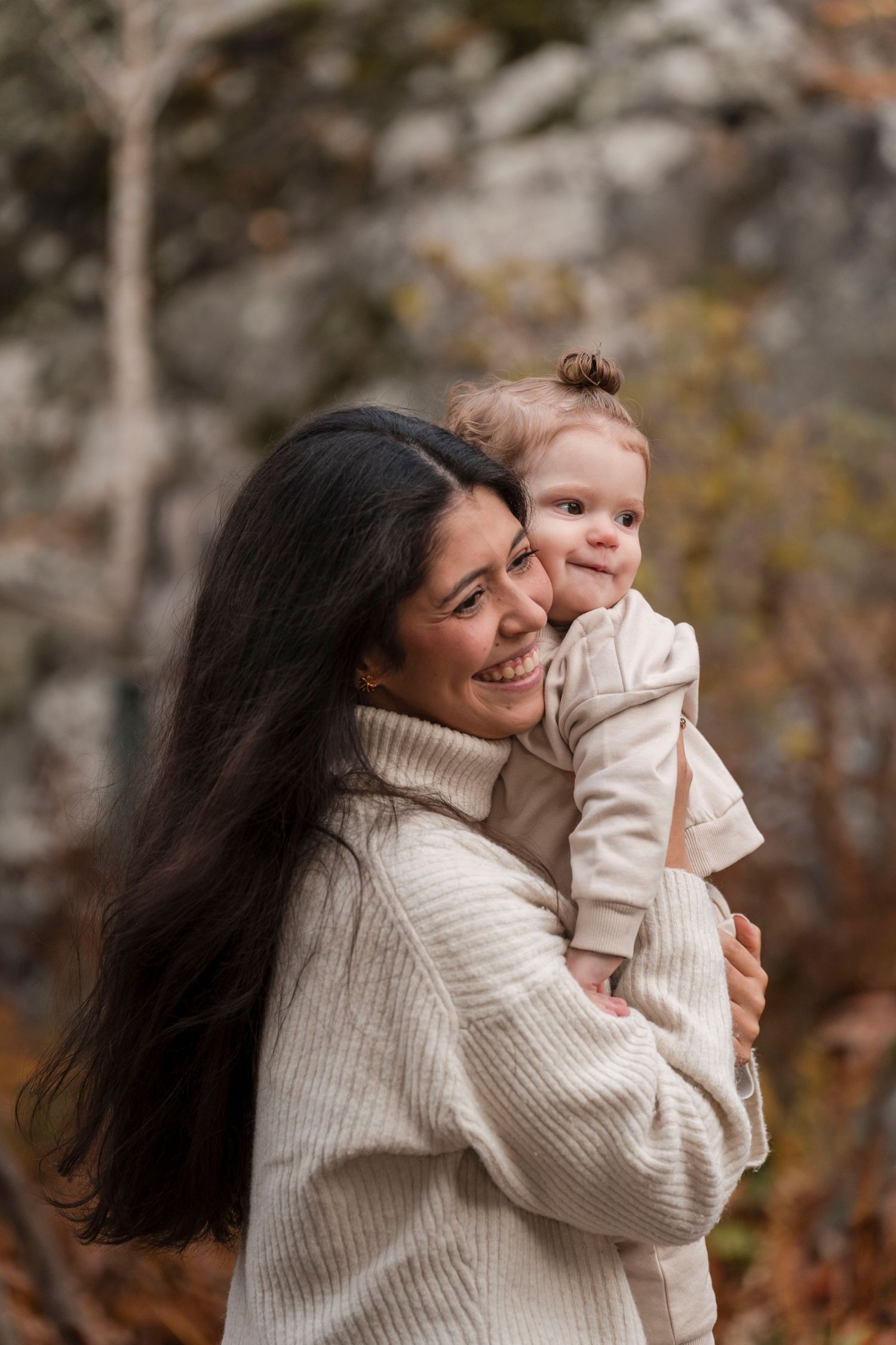 A mother and child share joyful moments together in a series of candid outdoor photos wearing matching cream sweaters.