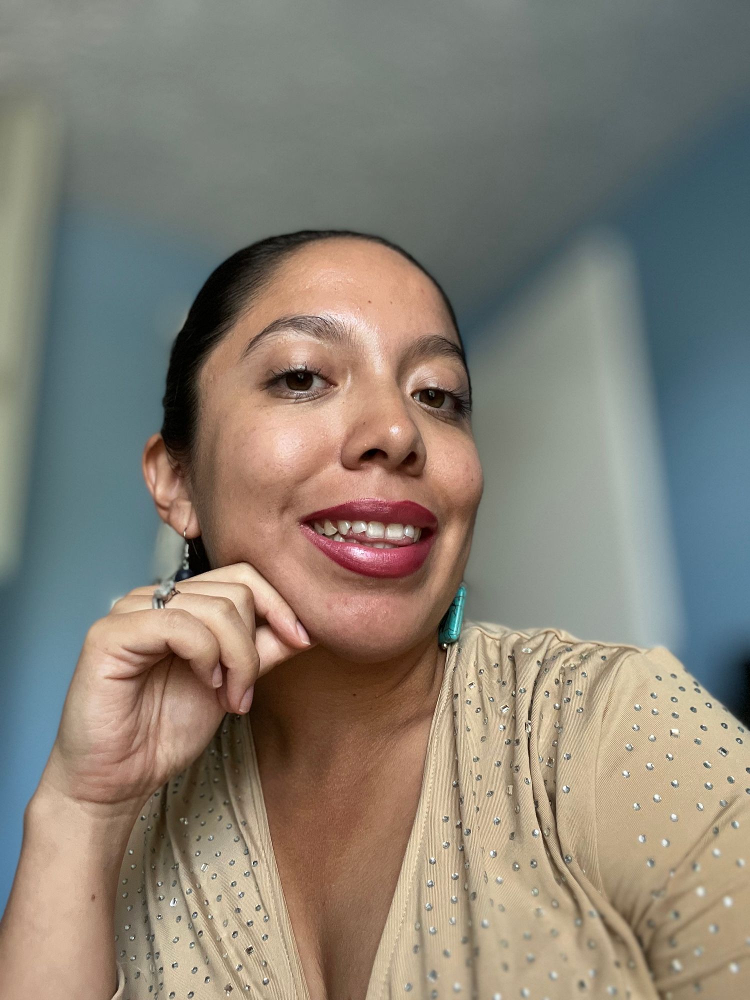 Close-up portrait wearing cream eyelet top and bold pink lipstick.