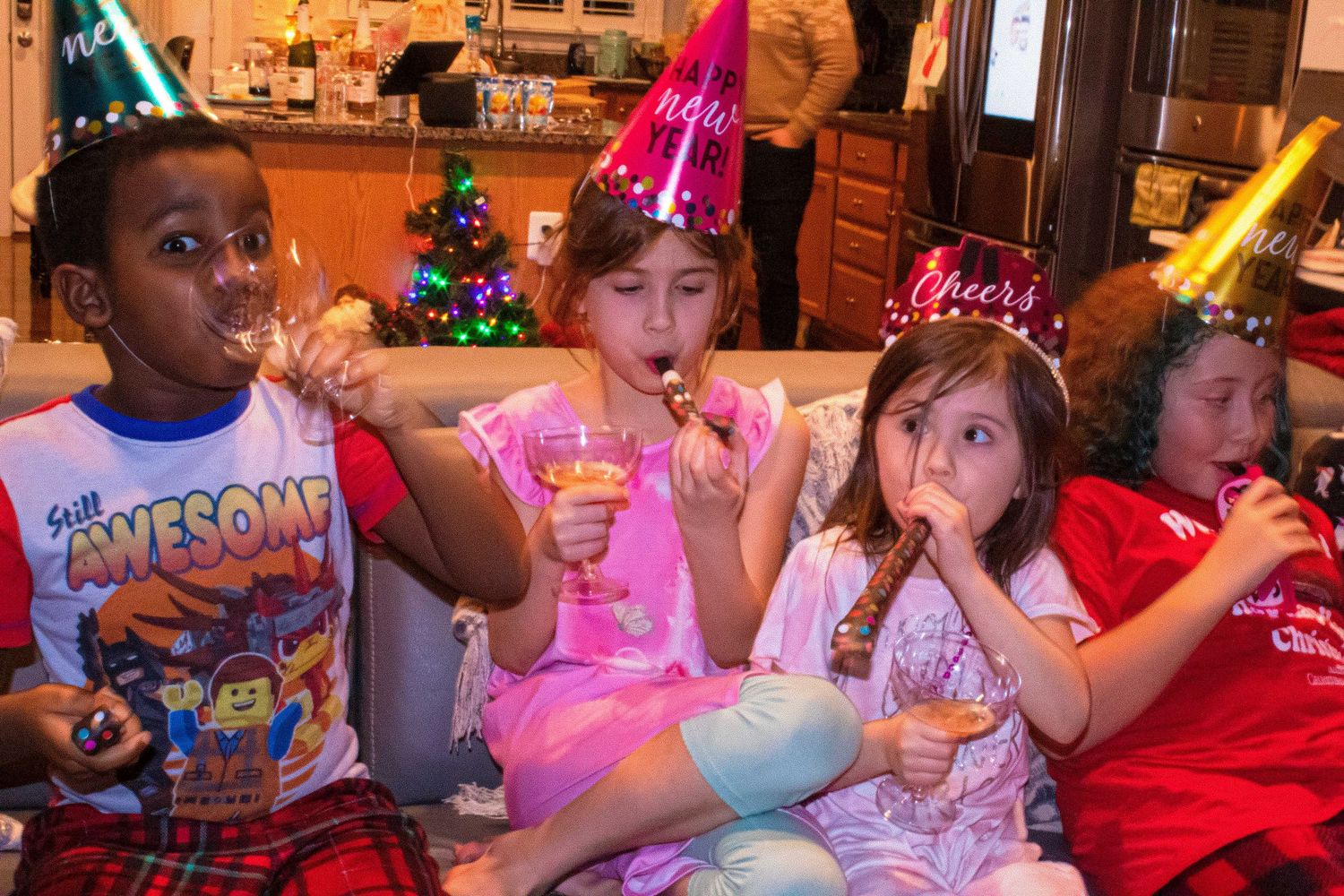 Children in festive party attire enjoy activities at a holiday celebration.