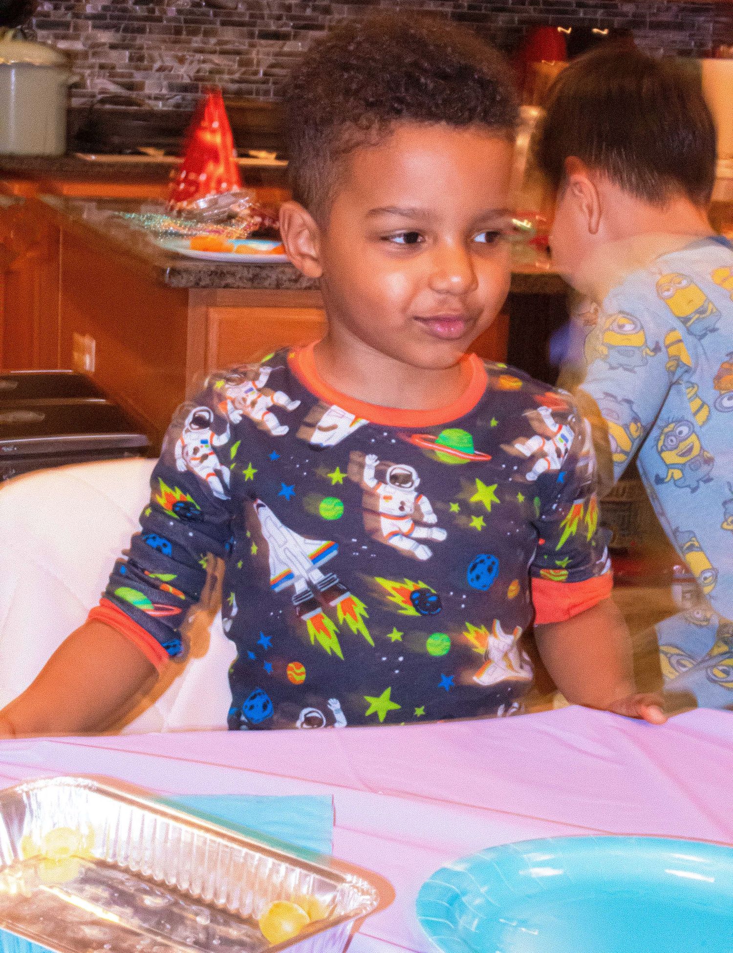 Young person in cosmic print shirt enjoying refreshments at a festive gathering.