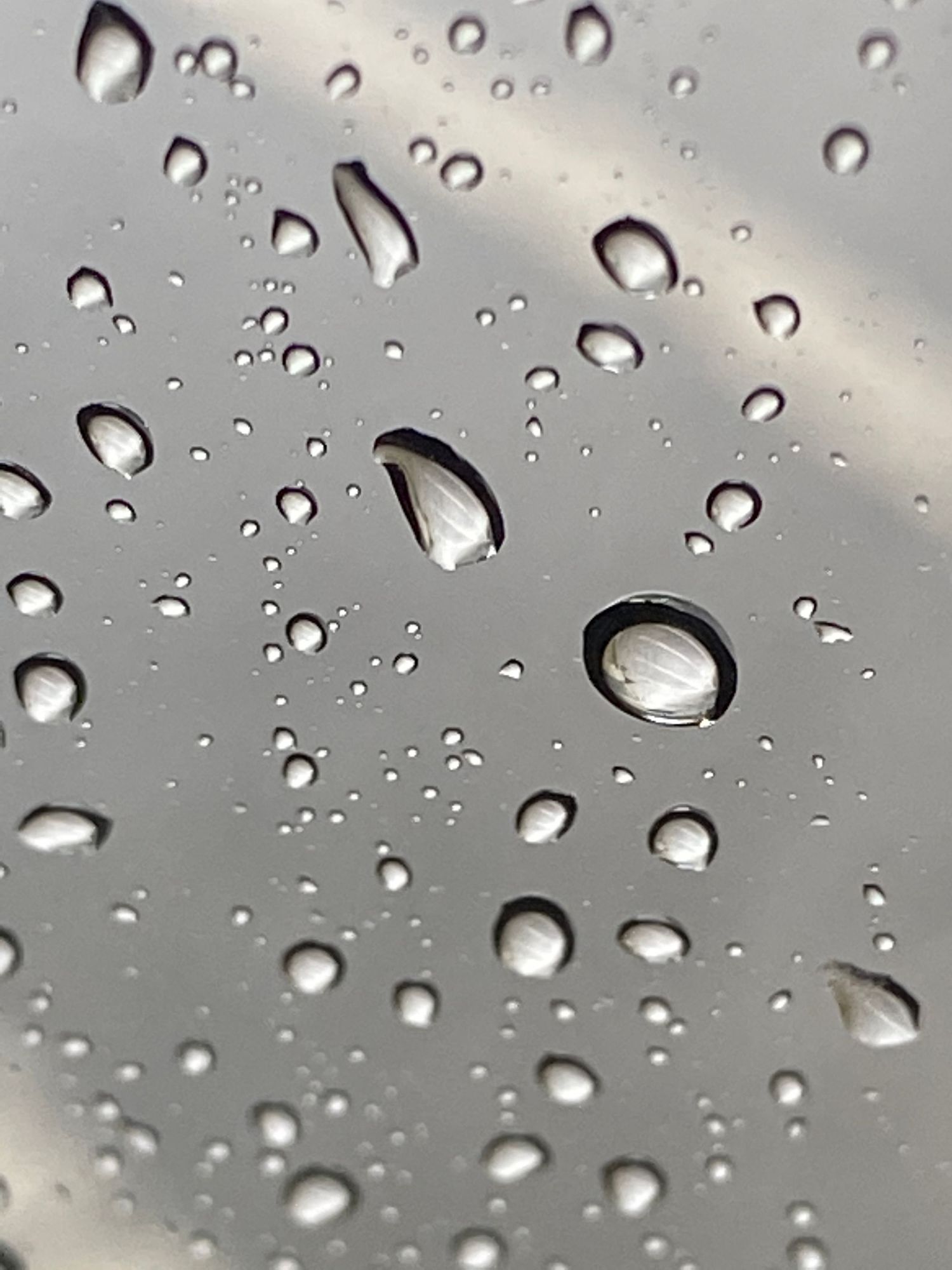 Macro photograph of water droplets on a gray surface creating a beautiful abstract pattern.
