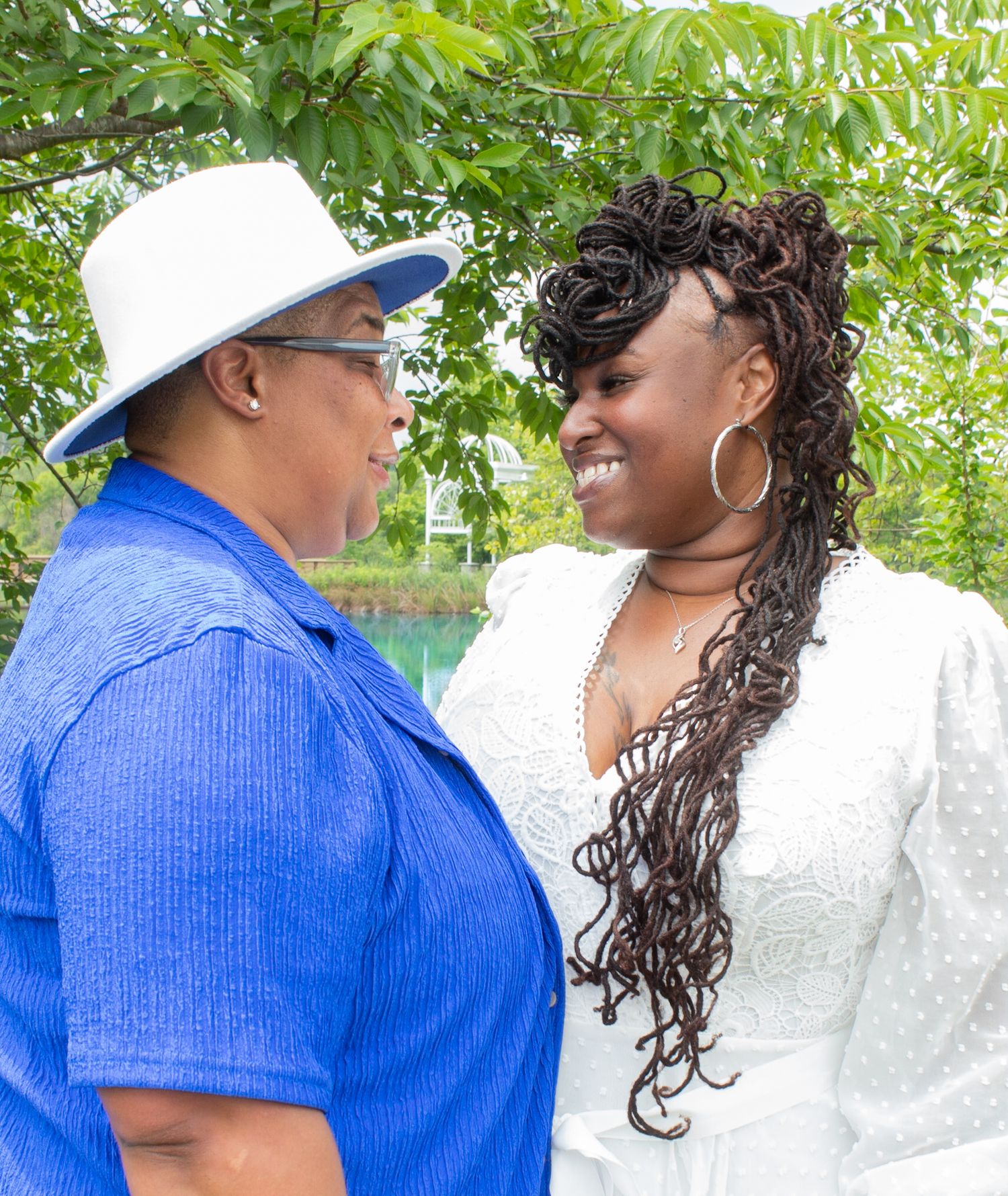 Side profile of couple in coordinating blue and white outfits in garden.