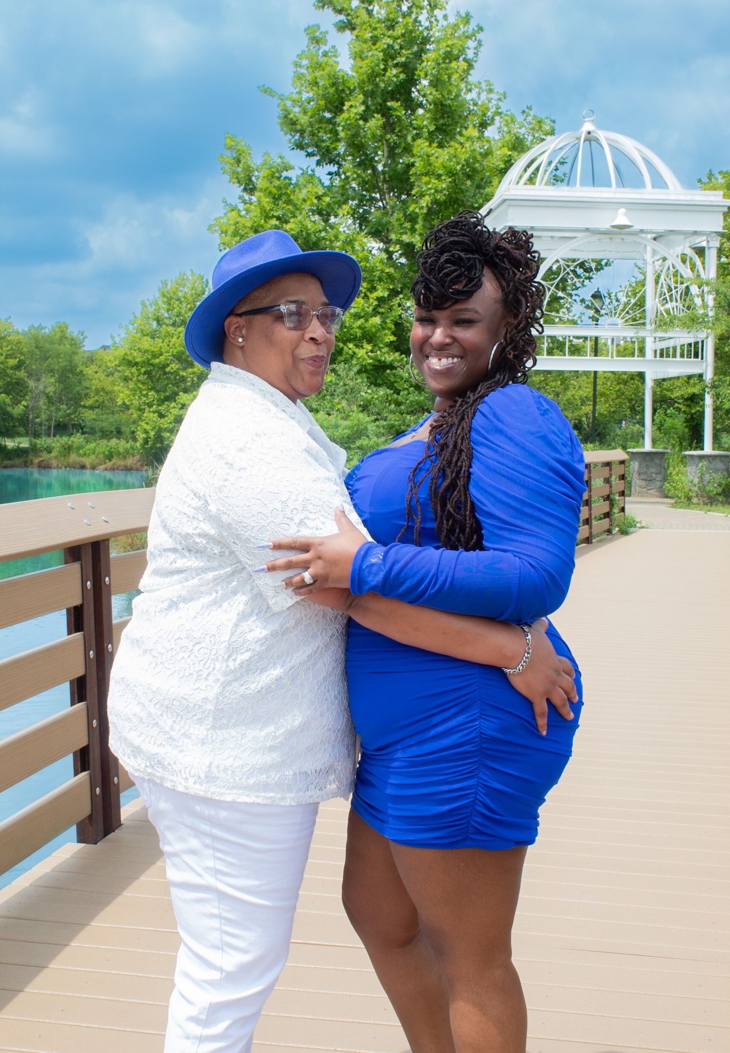 Intimate moment captured between two people in blue and white on scenic boardwalk.