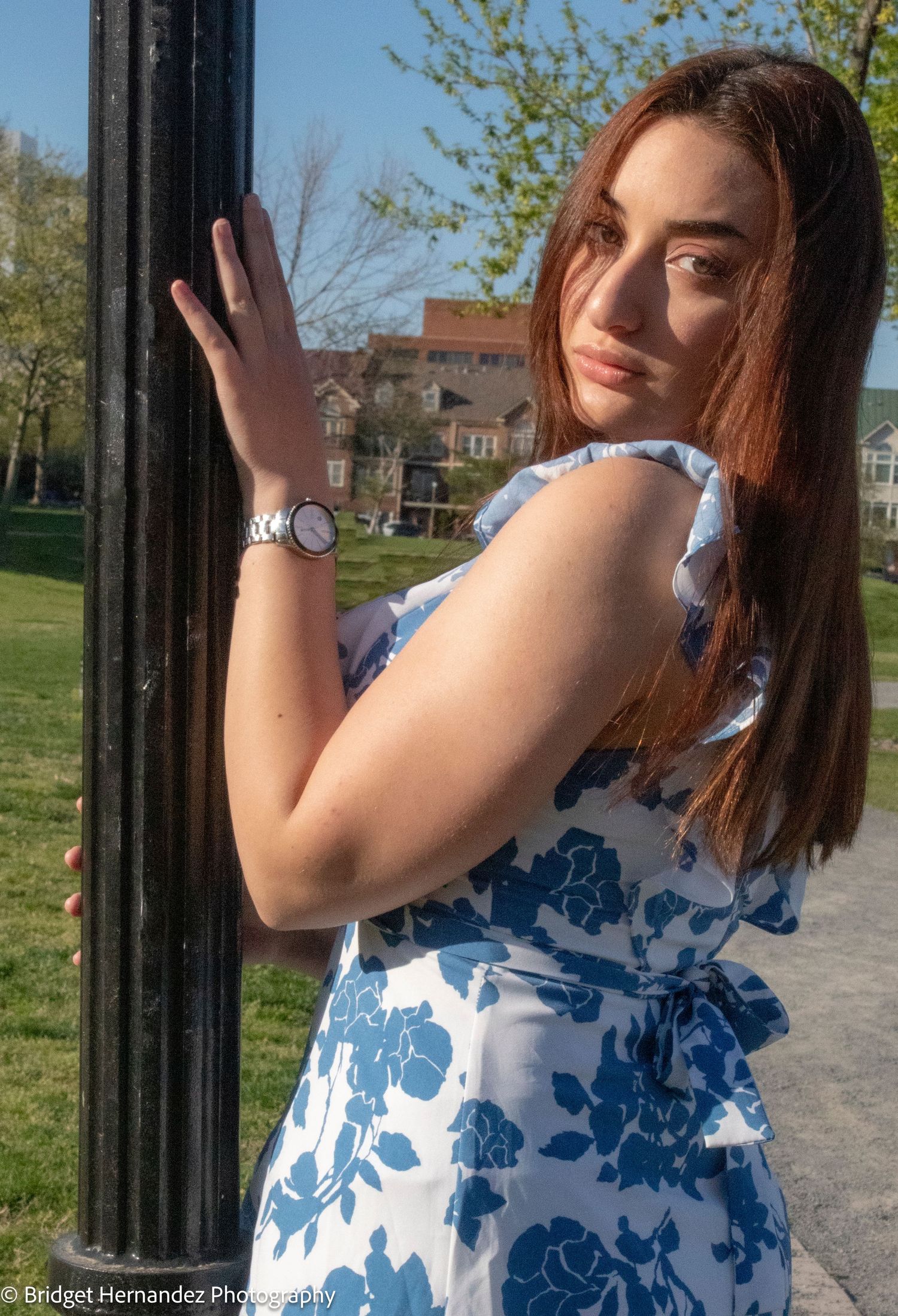 Springtime photoshoot showcasing a blue floral dress near a black lamppost.