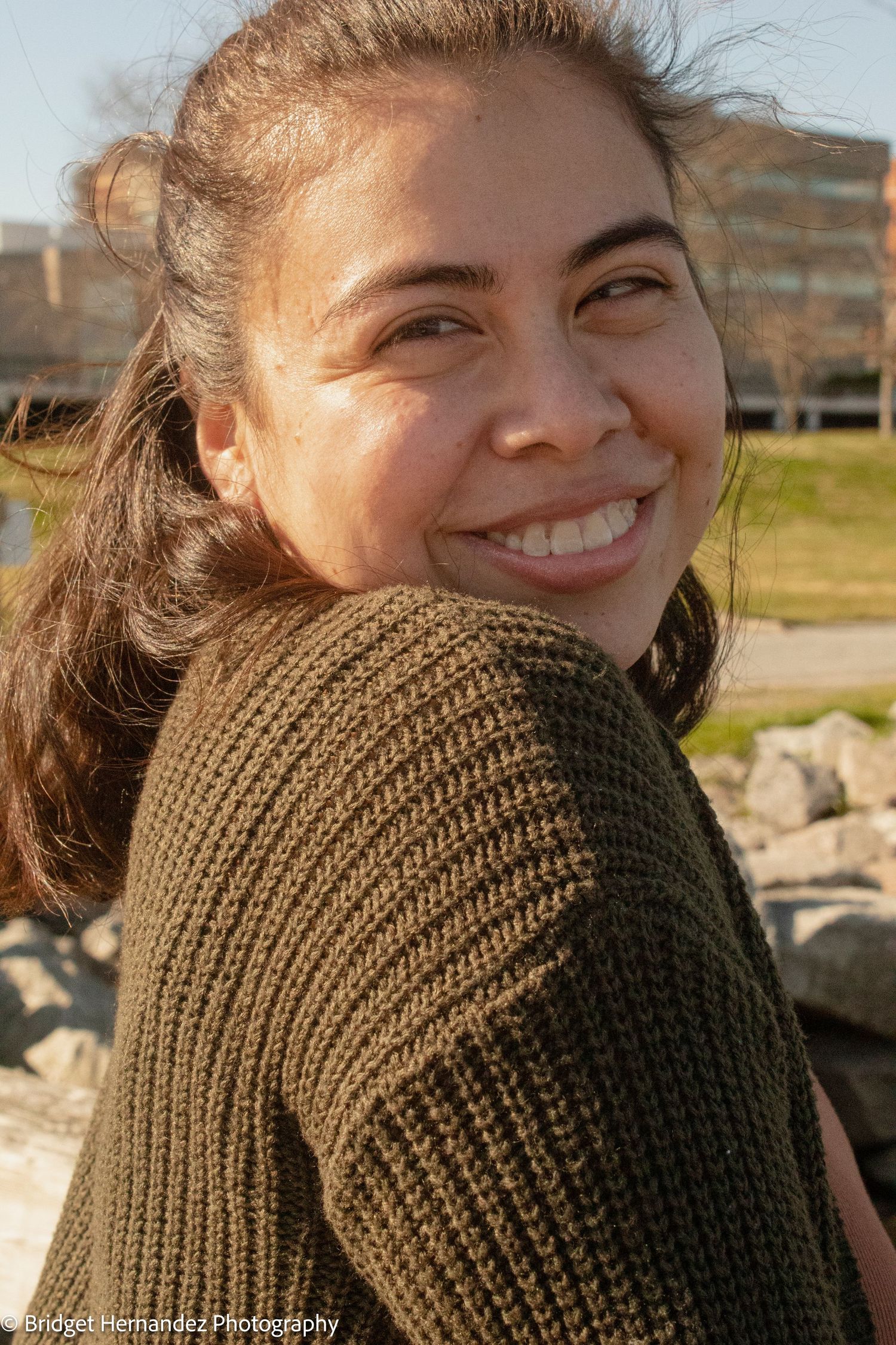 Candid expressions captured in warm sunlight wearing brown knit sweater.