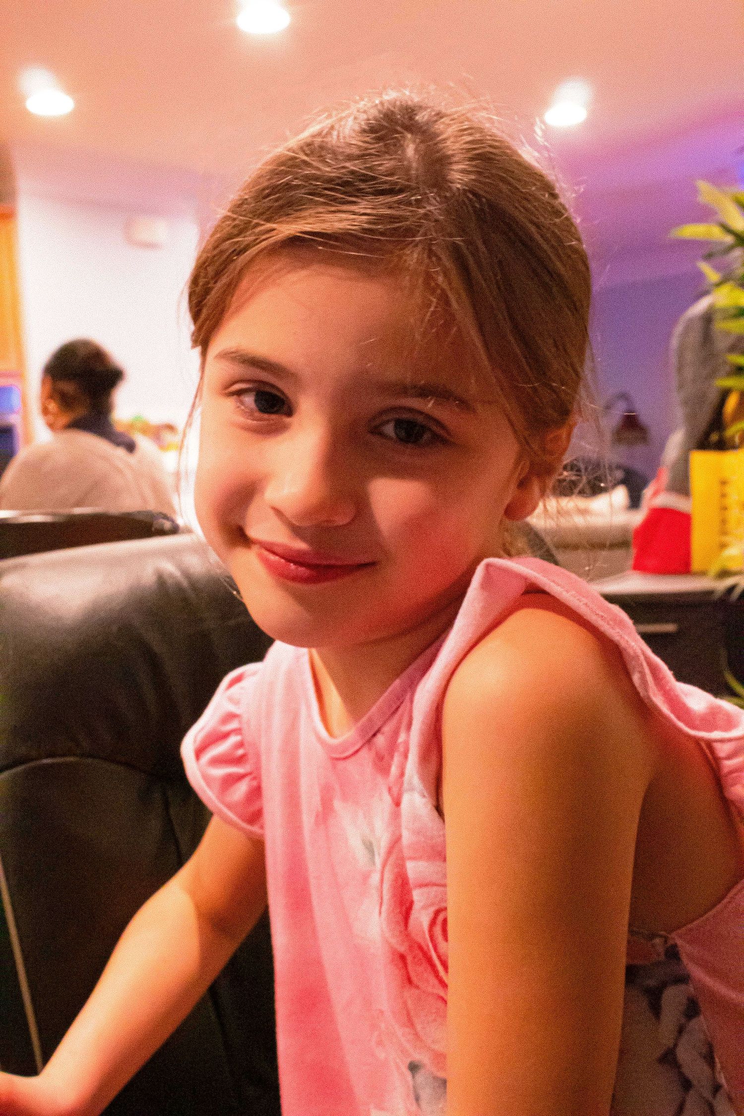 Young person in pink wearing a joyful expression during what appears to be a party celebration.