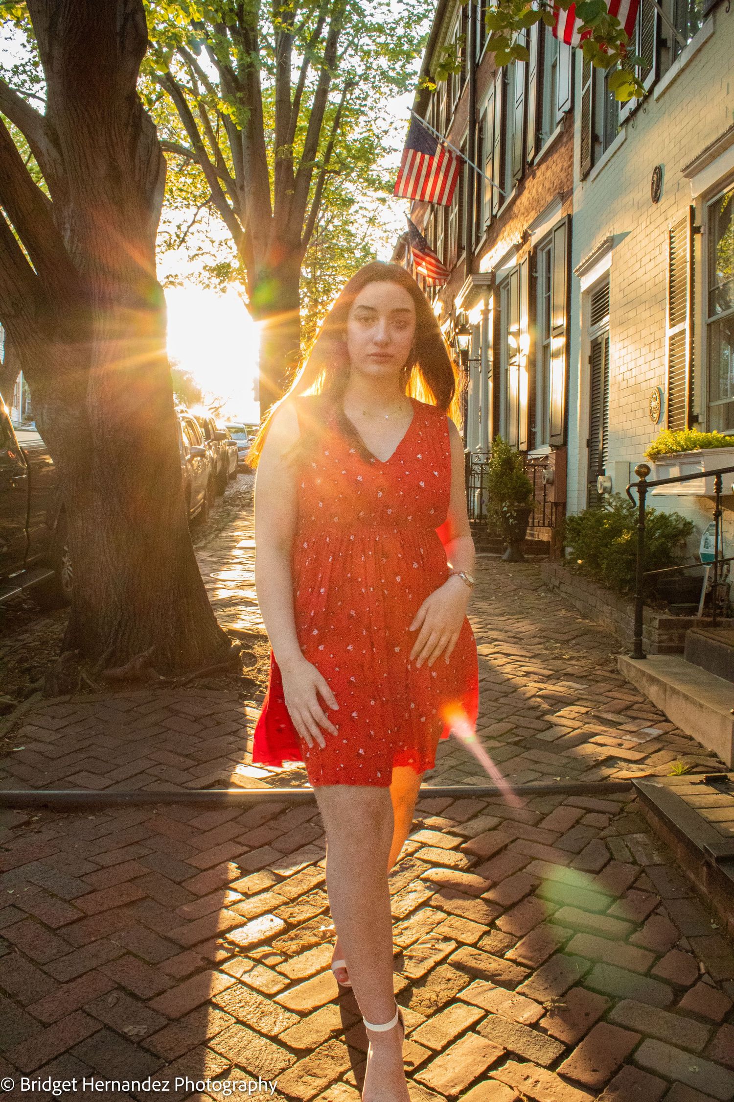 Red dress photographed on a brick sidewalk during golden hour.