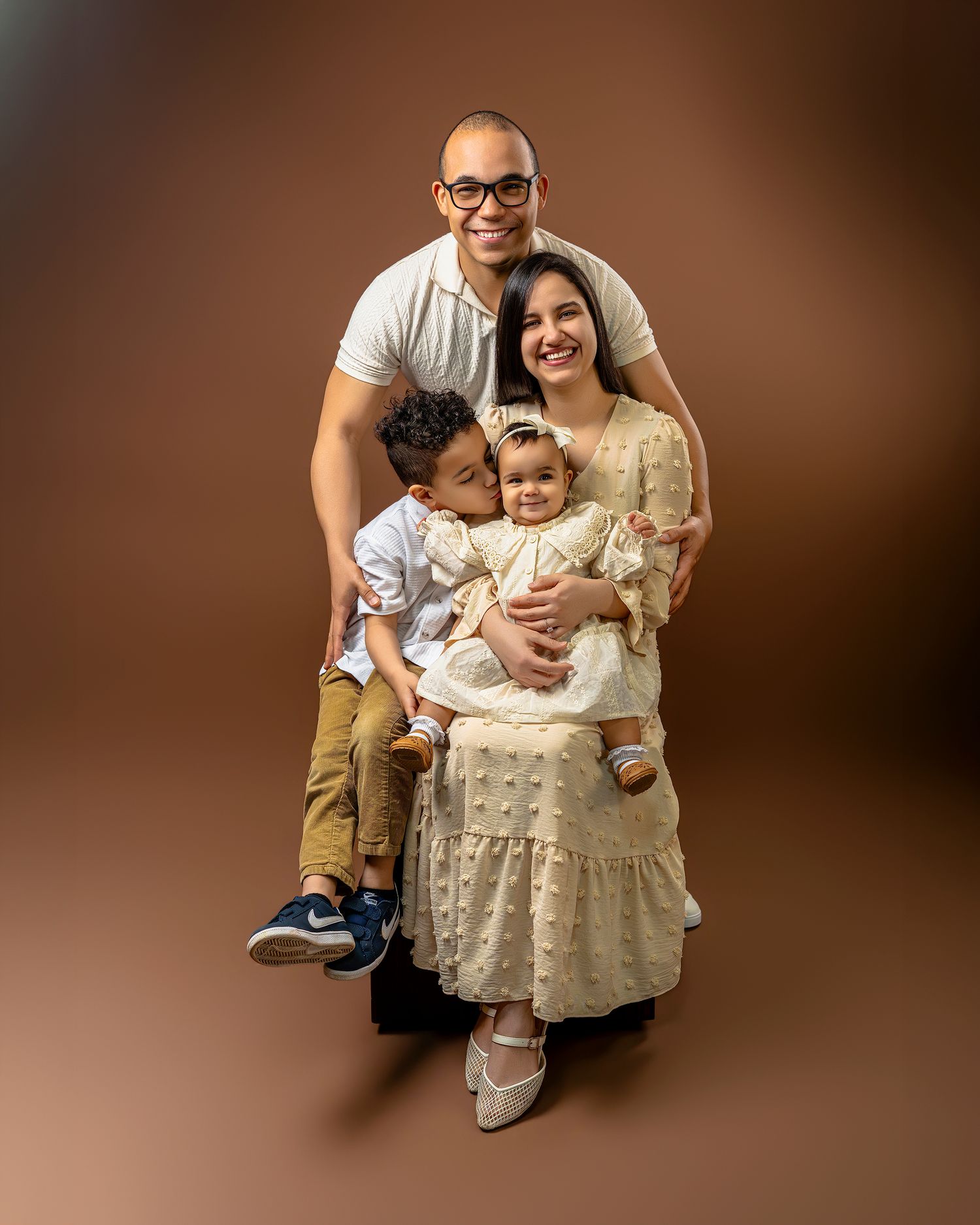 Professional studio portraits of family members in warm brown tones showing progression of growth and relationships.