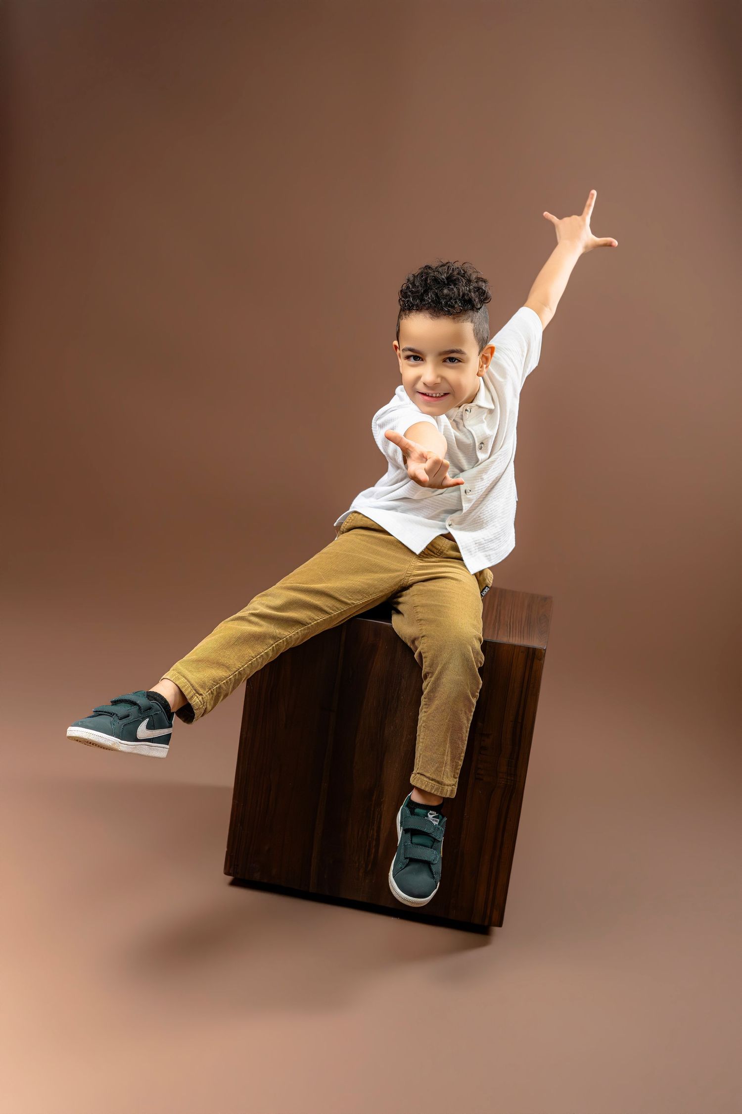 A sequence of dynamic action shots showing someone jumping and flipping on a brown couch against a neutral backdrop.
