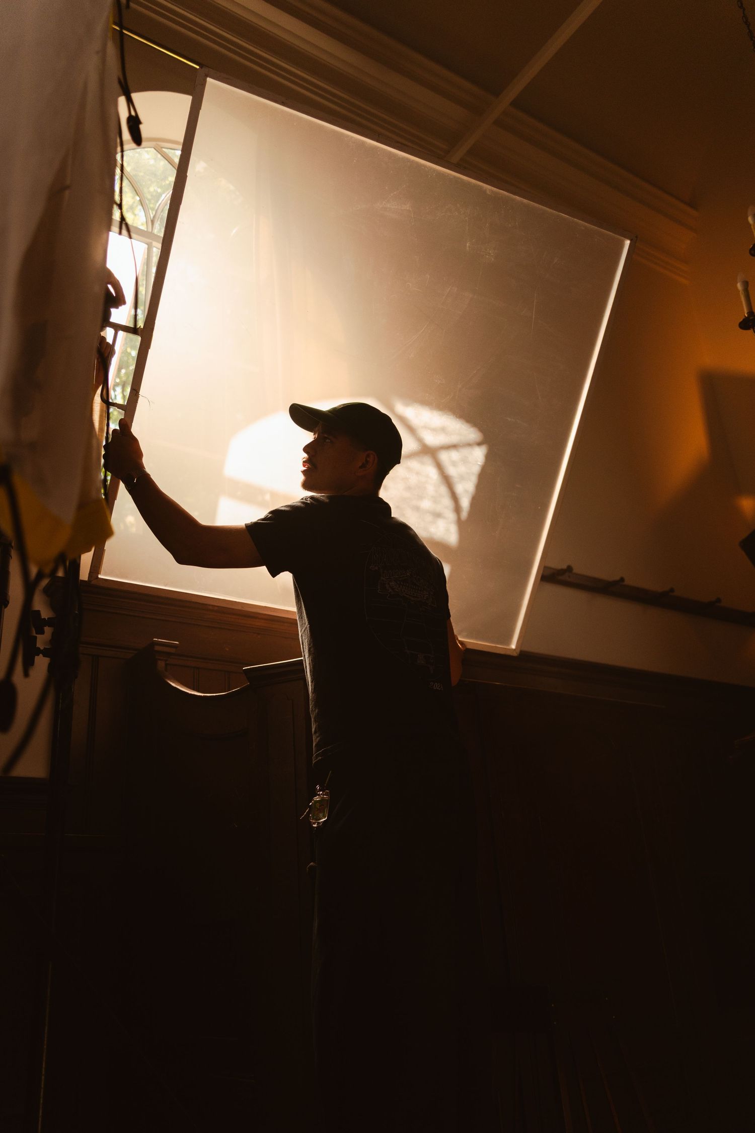 Dark silhouettes backlit by bright studio lighting create dramatic shadows during a professional film or photo shoot production.