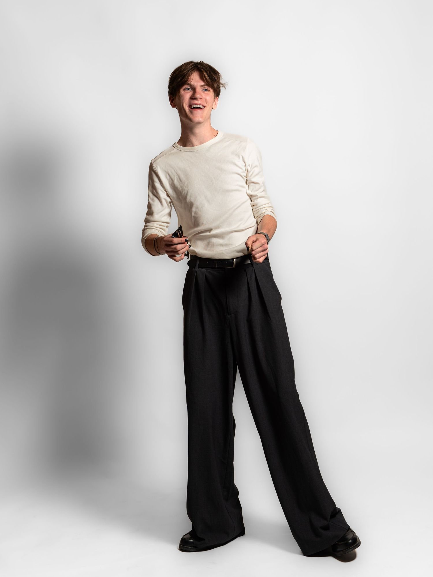 A classic black and white outfit featuring a cozy sweater and wide-leg trousers shown in four different poses.