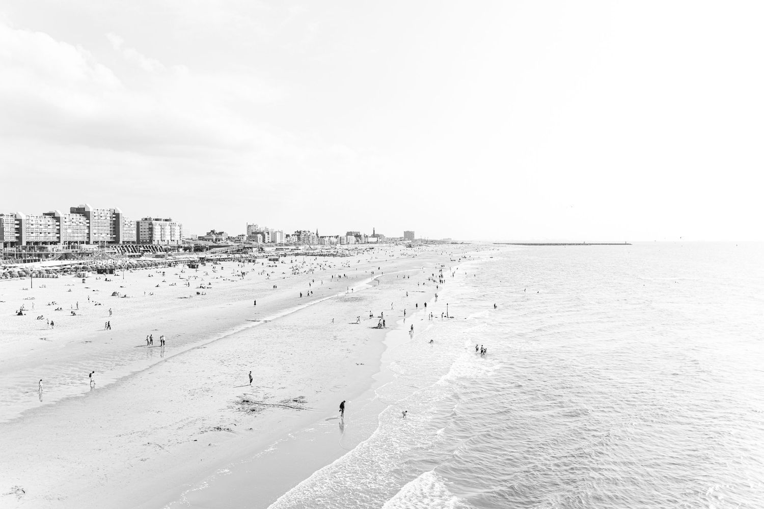 A panoramic black and white photograph shows the Atlantic City boardwalk and beach with hotels and buildings lining the coast.