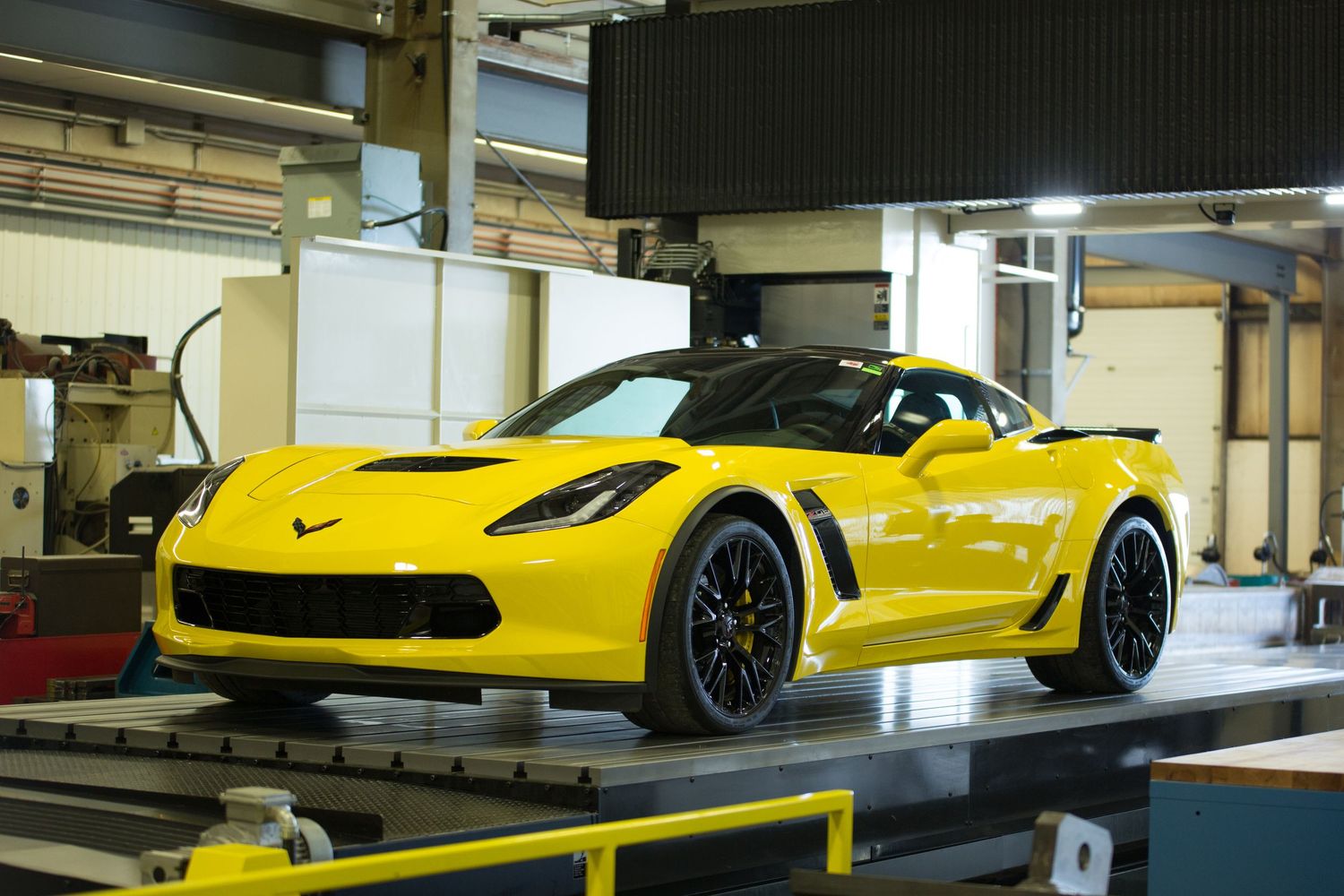 Four views of a bright yellow Chevrolet Corvette C8 Z06 sports car displayed in an indoor showroom setting.
