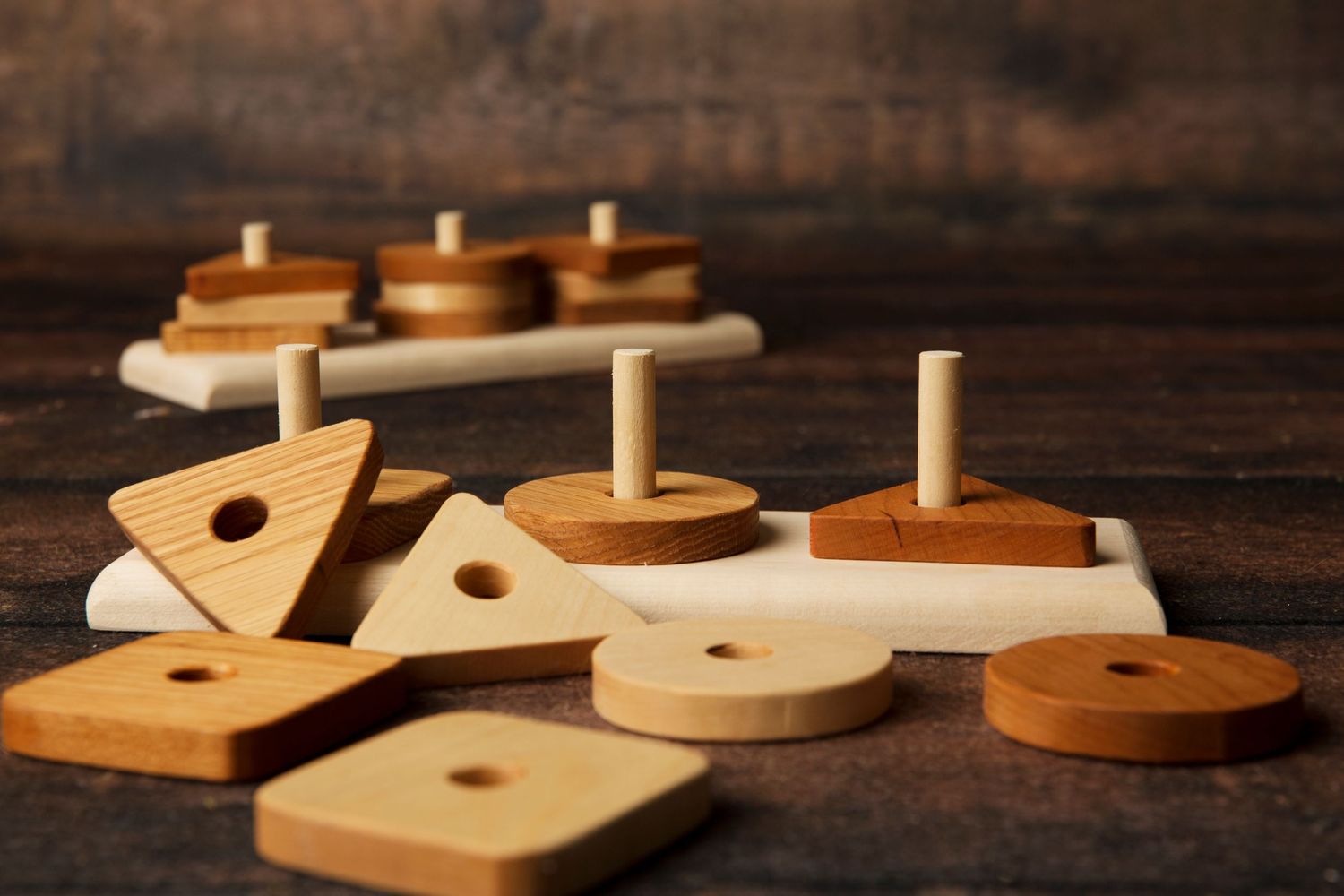 Wooden domino pieces arranged in sequence on dark rustic wooden background showing progression of falling motion.