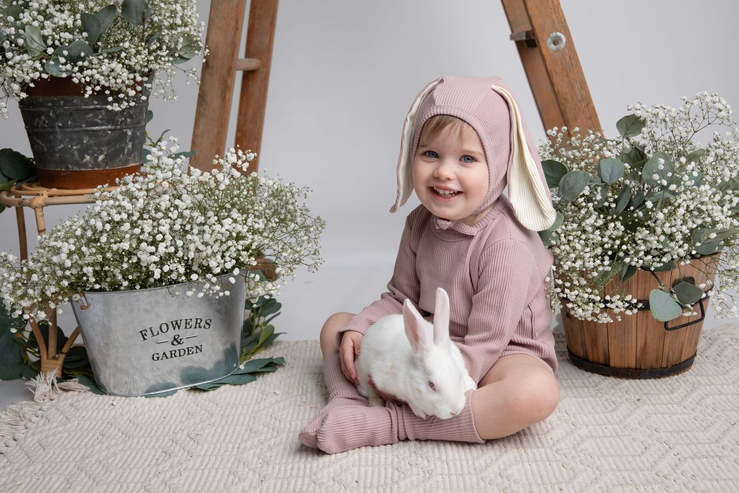 Spring themed photo session with rustic decor, white flowers and bunny props.