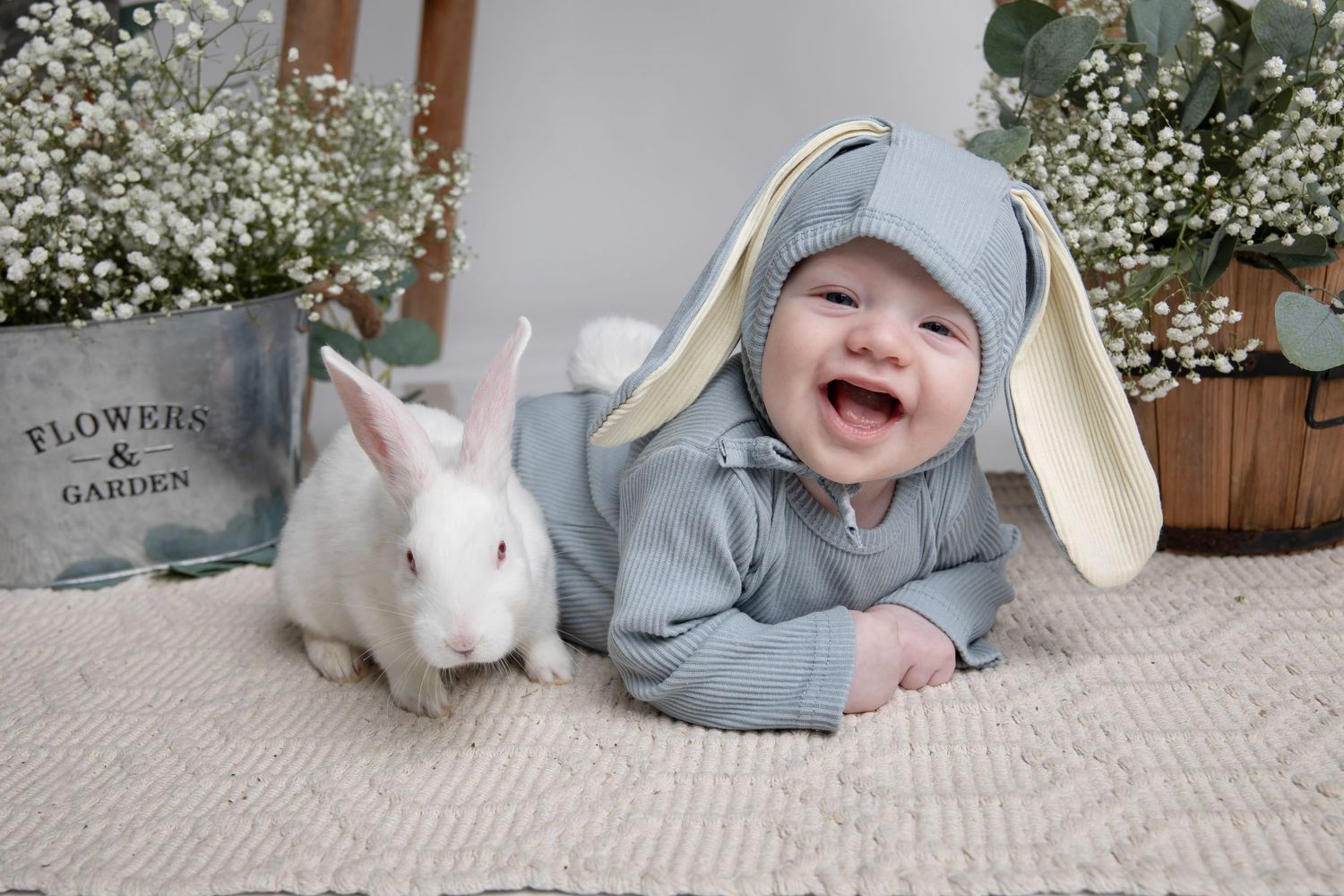 Easter mini session setup with baby breath flowers, bunnies and garden themed props.