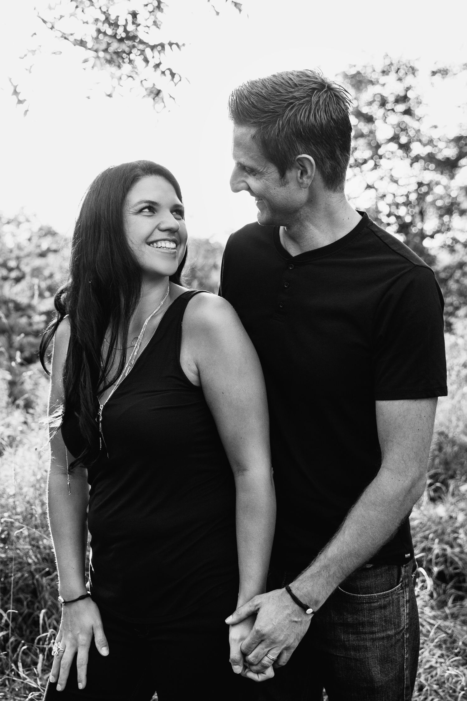 A romantic black and white photo sequence of a couple holding hands and embracing outdoors.