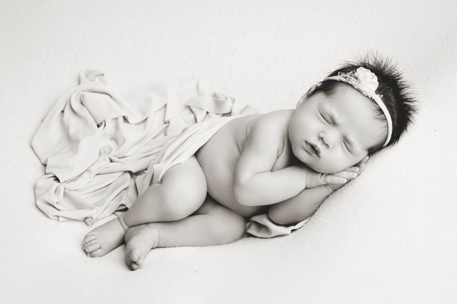 Black and white artistic photo series showing a sleeping baby in four peaceful resting positions.