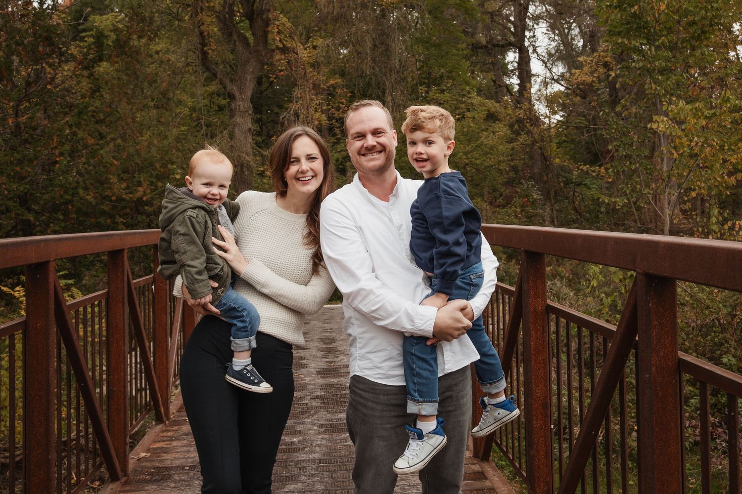 Group family photos on a wooden deck surrounded by autumn trees.