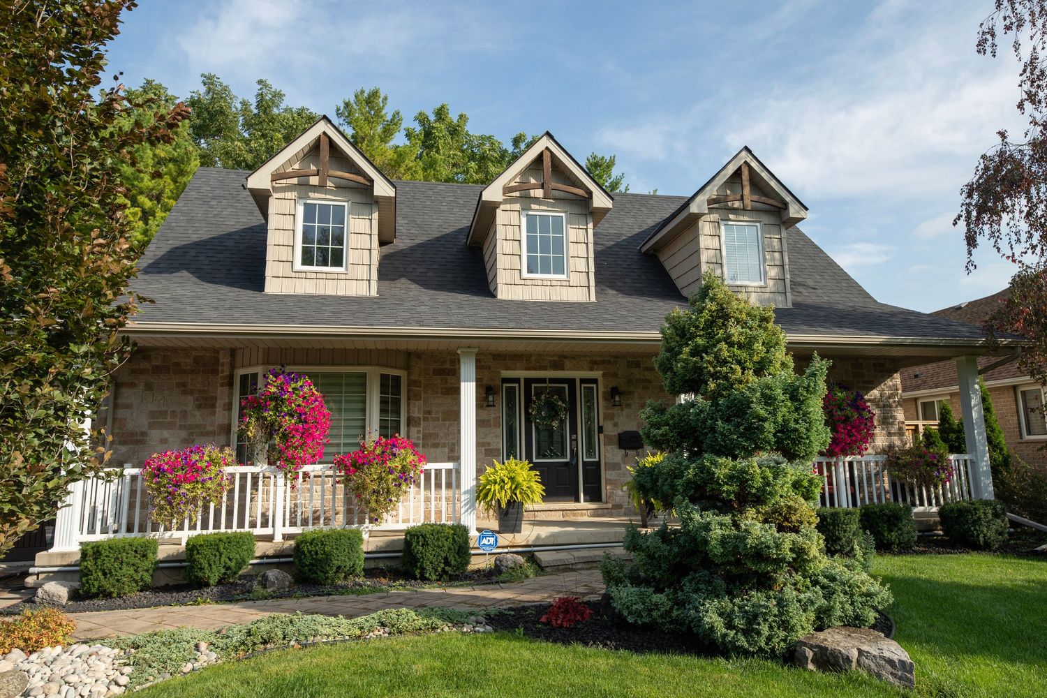 Panoramic view of multiple ranch-style homes with landscaped yards and covered porches on a sunny day.