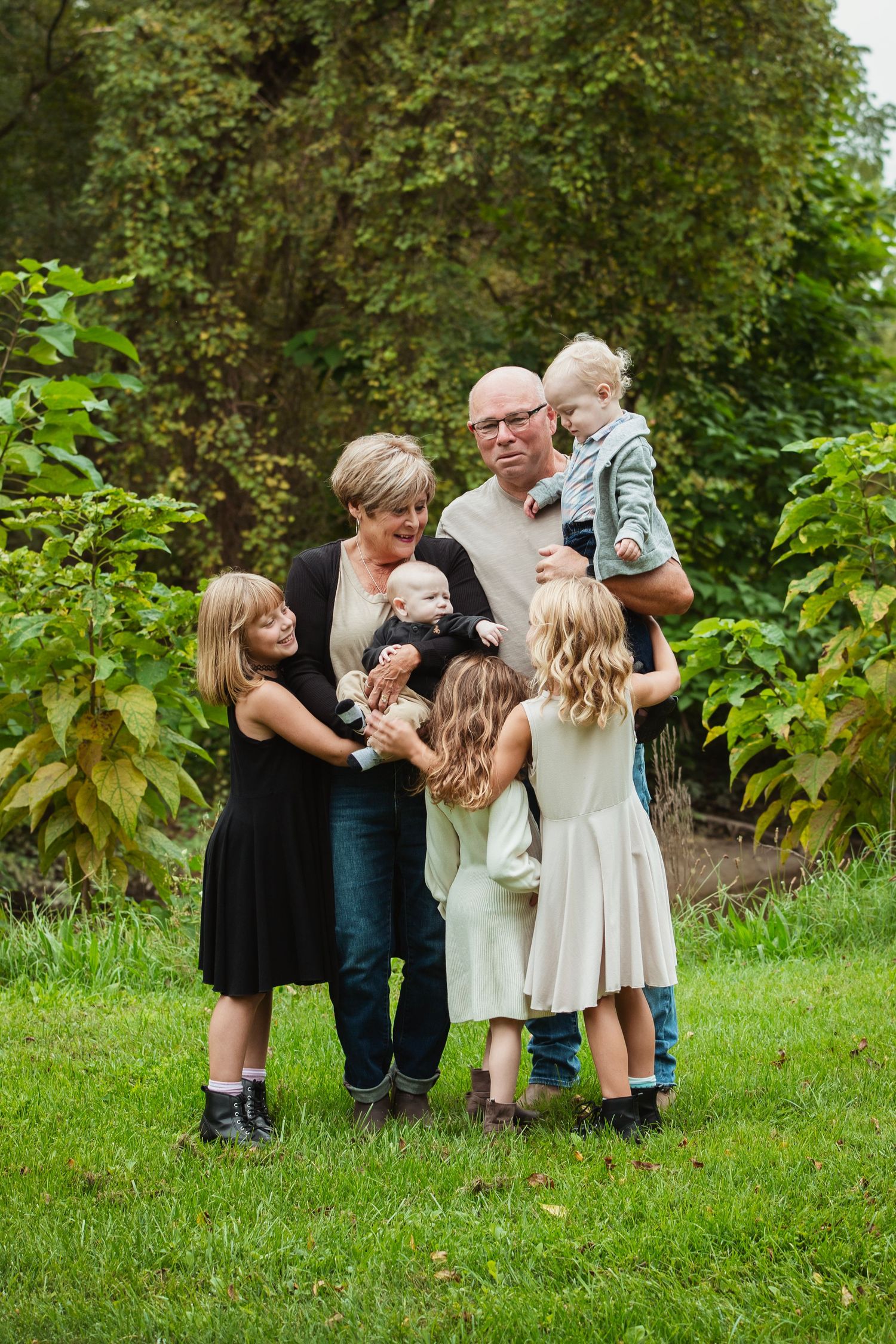 Family group sharing an intimate moment together in a green garden setting.