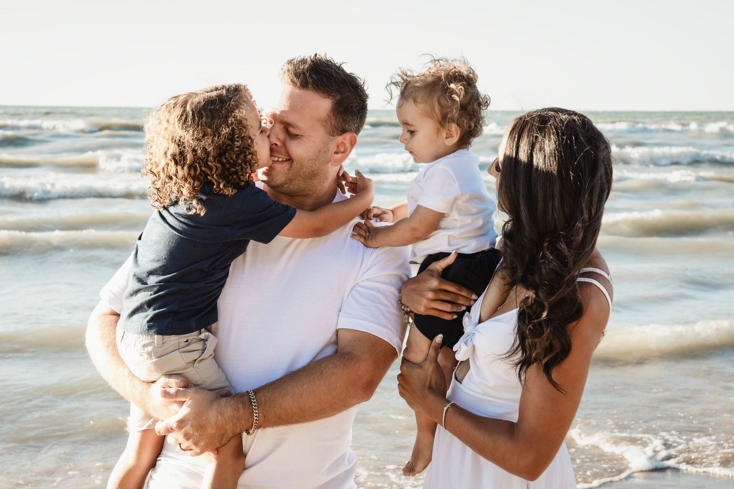 Intimate family moment captured during sunset beach photo session.